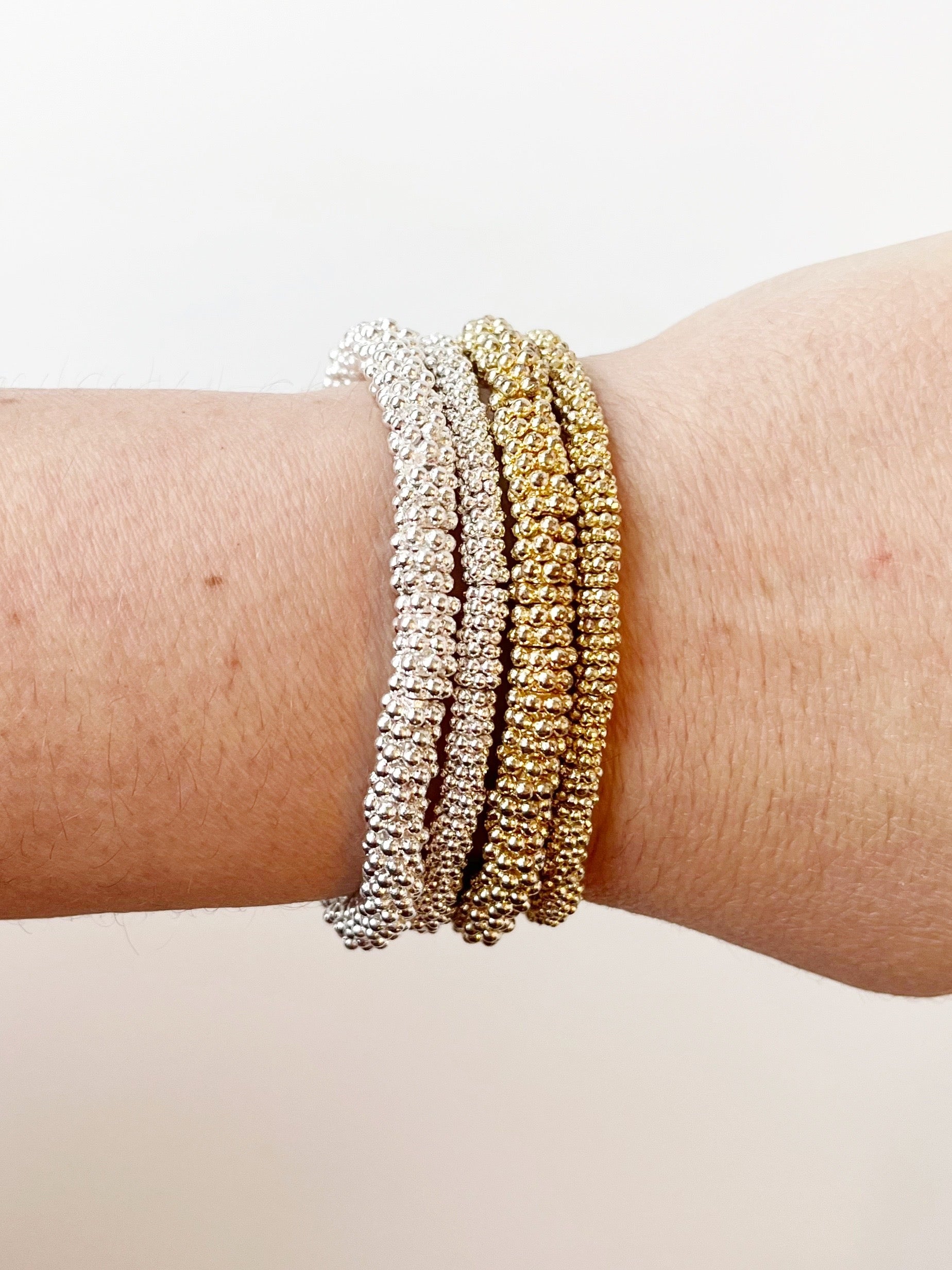 set of 4 gold and silver bead bracelet bundle displayed on wrist