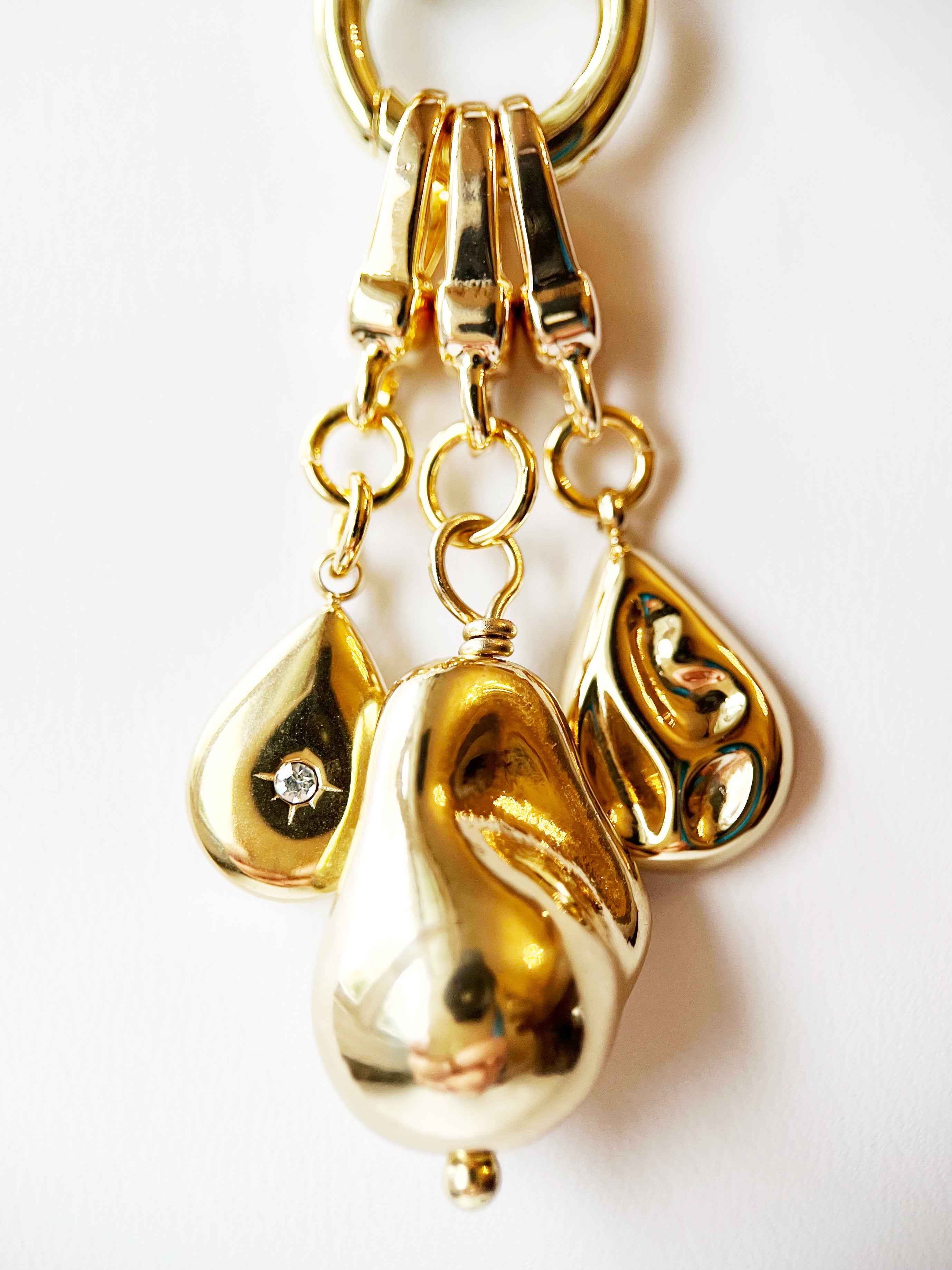 Gold keychain with teardrop-shaped pendants on a white background