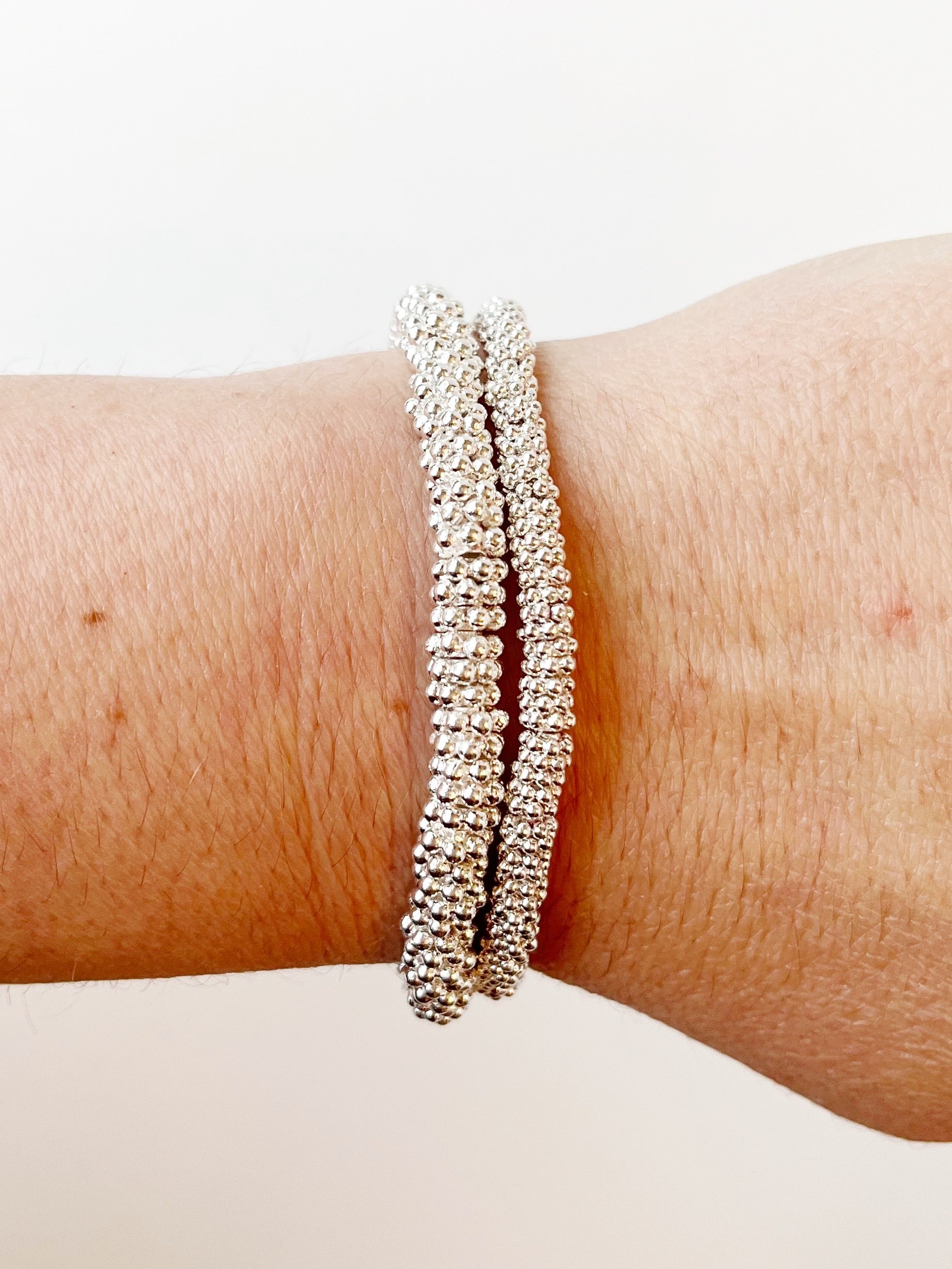 silver stacked bracelets on wrist