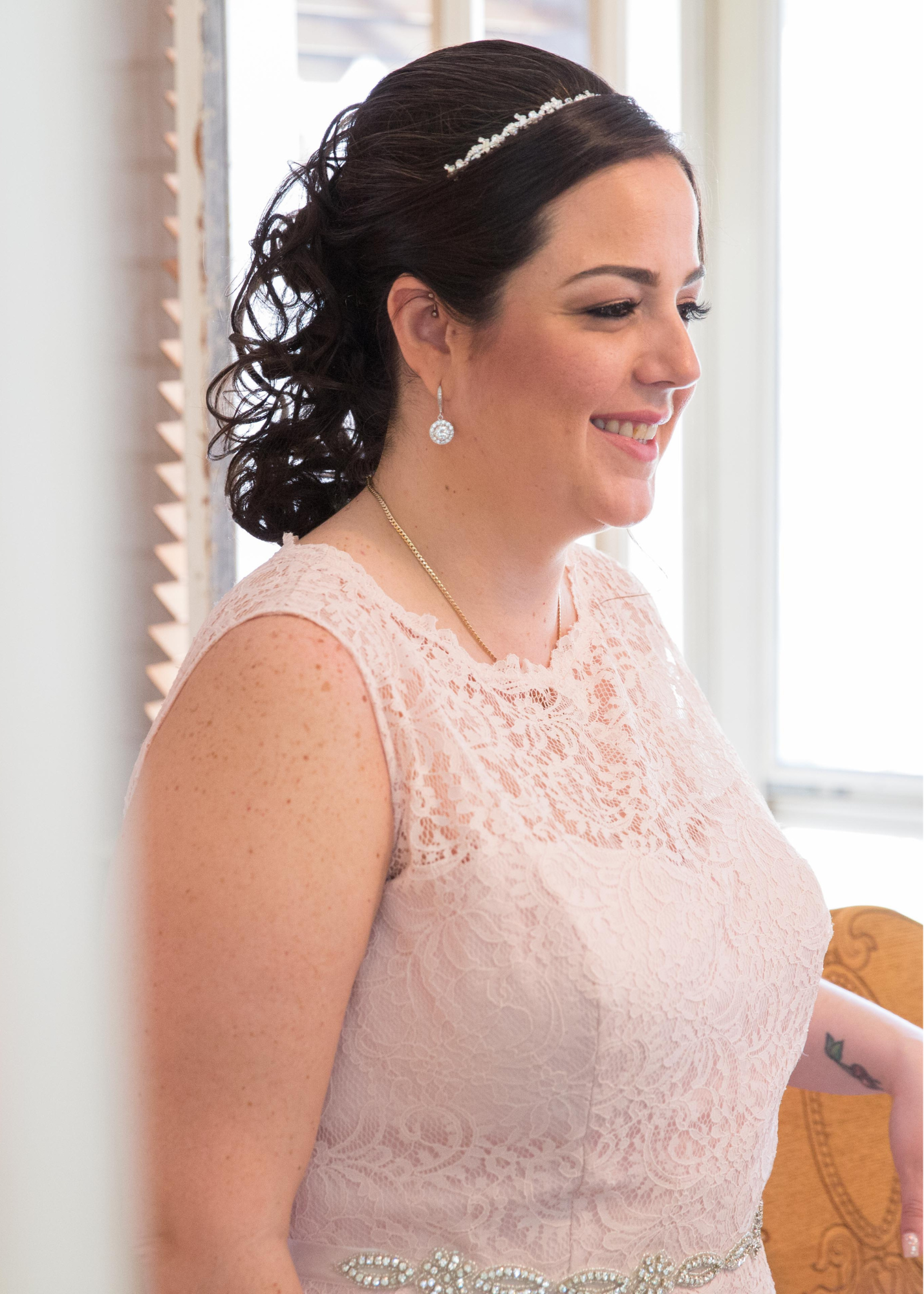 Bride standing by window while wearing Round Clear cubic zirconia Crystal Stud Earrings with halo in a silver colored rhodium plated brass setting