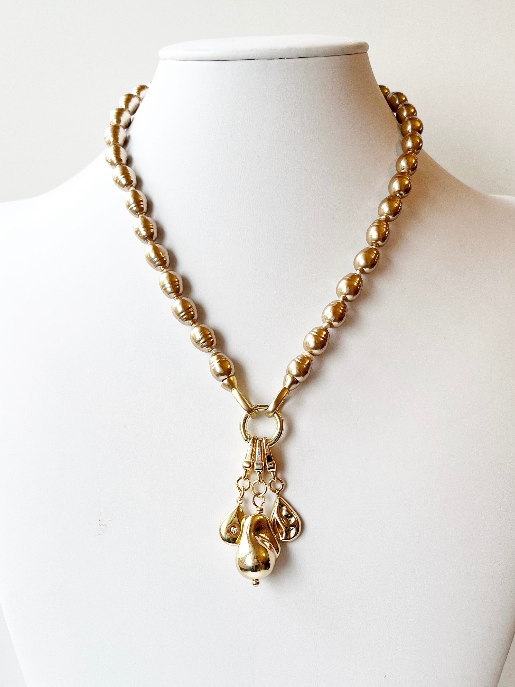 Gold necklace with a pendant on a mannequin against a white background