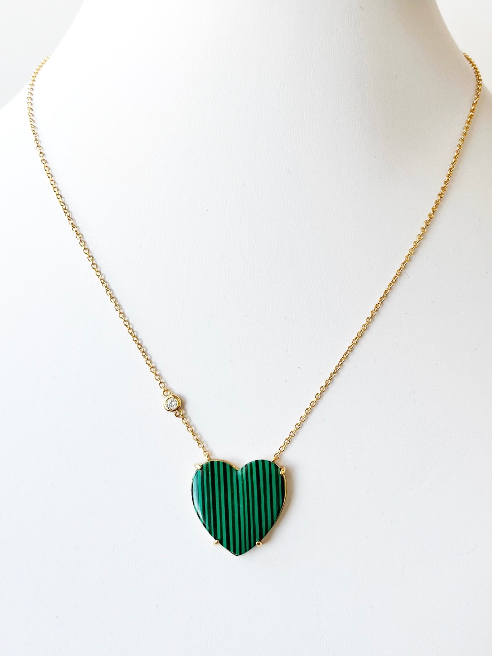 Necklace with a green heart-shaped pendant on a white background