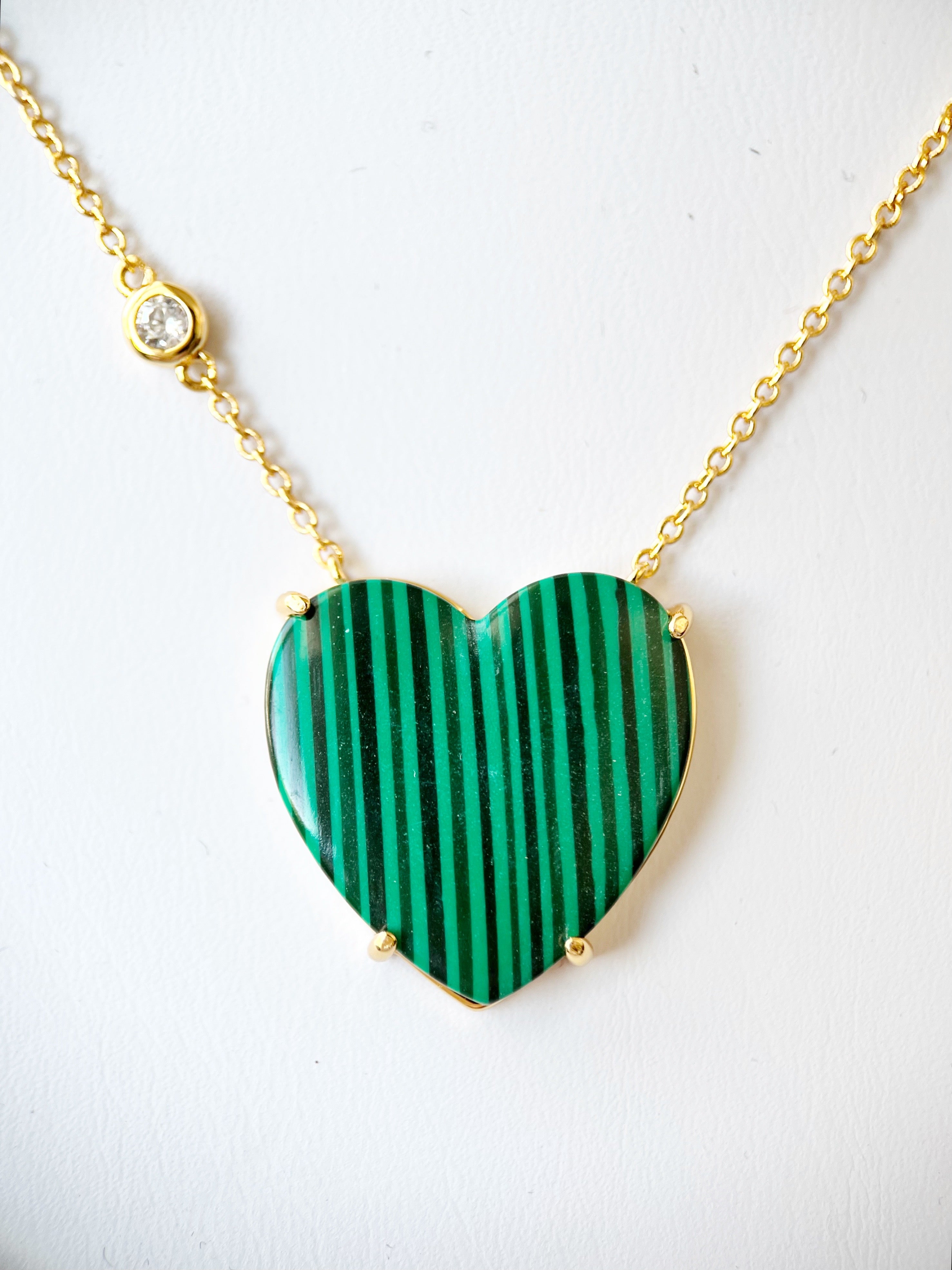 Heart-shaped green pendant necklace on a white background
