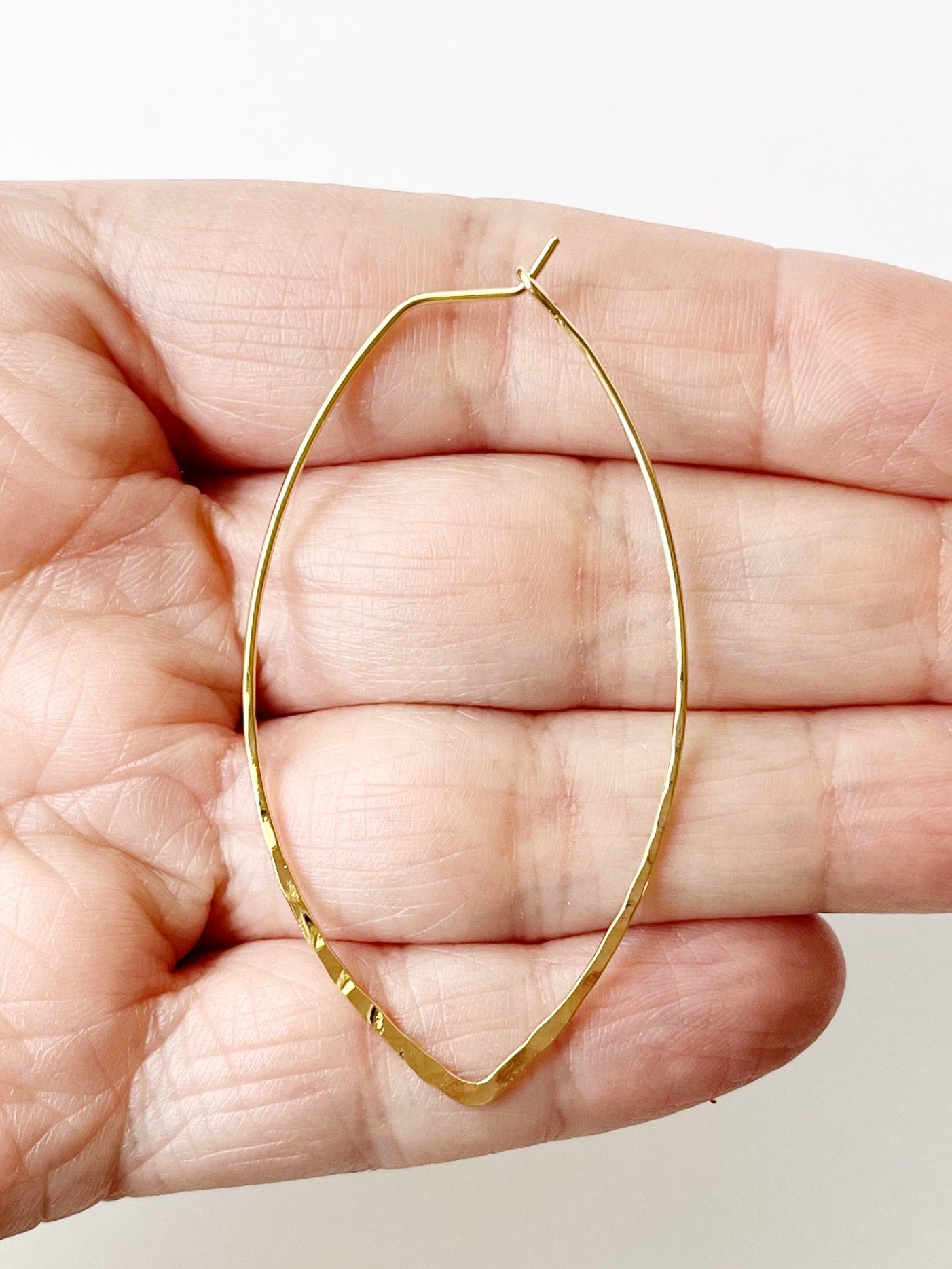 gold minimalist earrings on hand