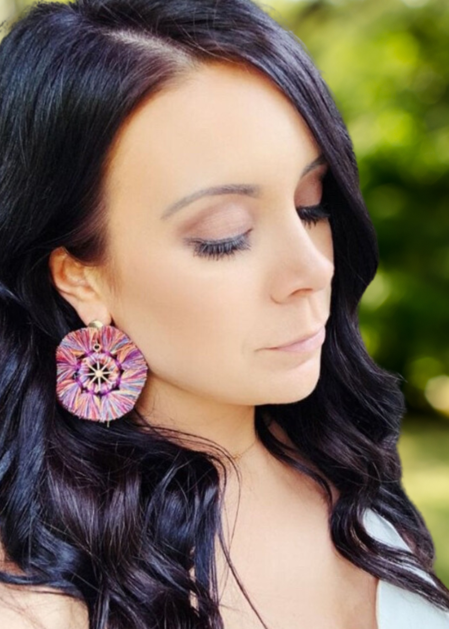 rainbow and gold tassel earrings on woman