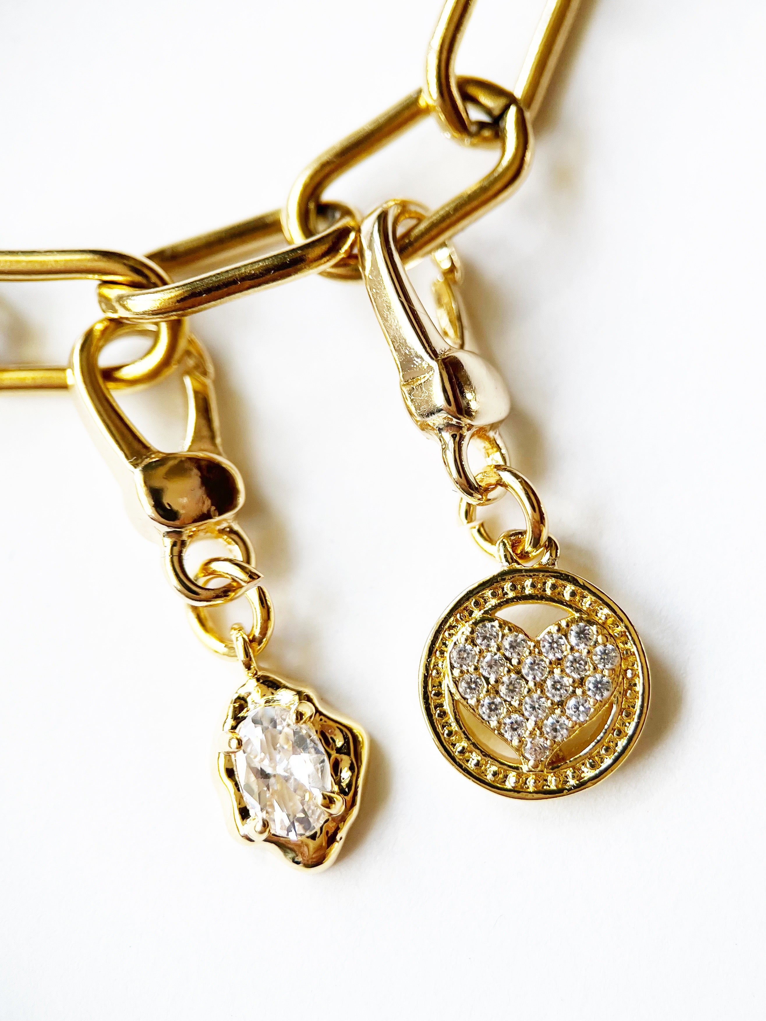 Gold bracelet with heart-shaped charm and clear gemstone