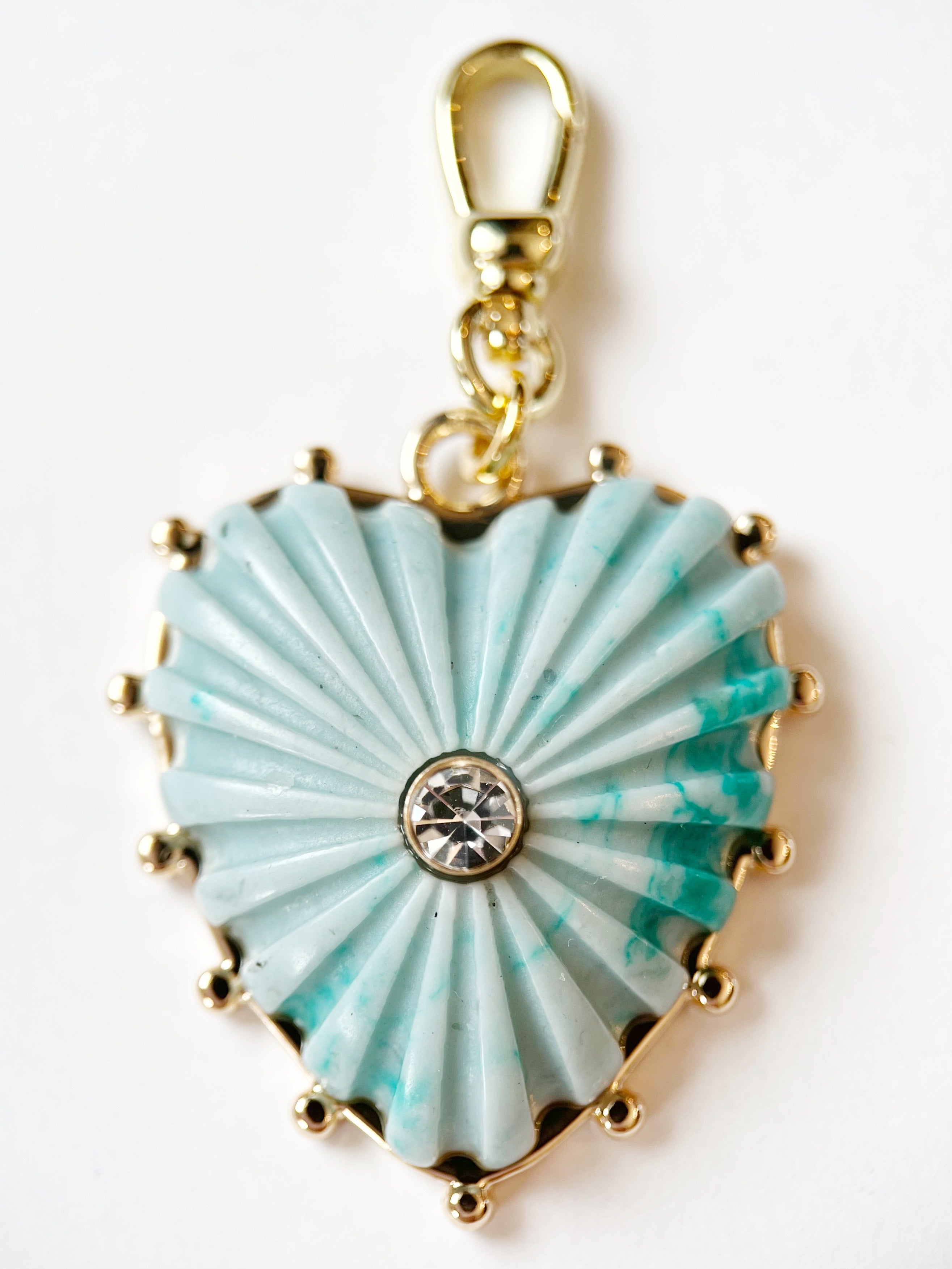 Heart-shaped turquoise pendant with gold accents on a white background
