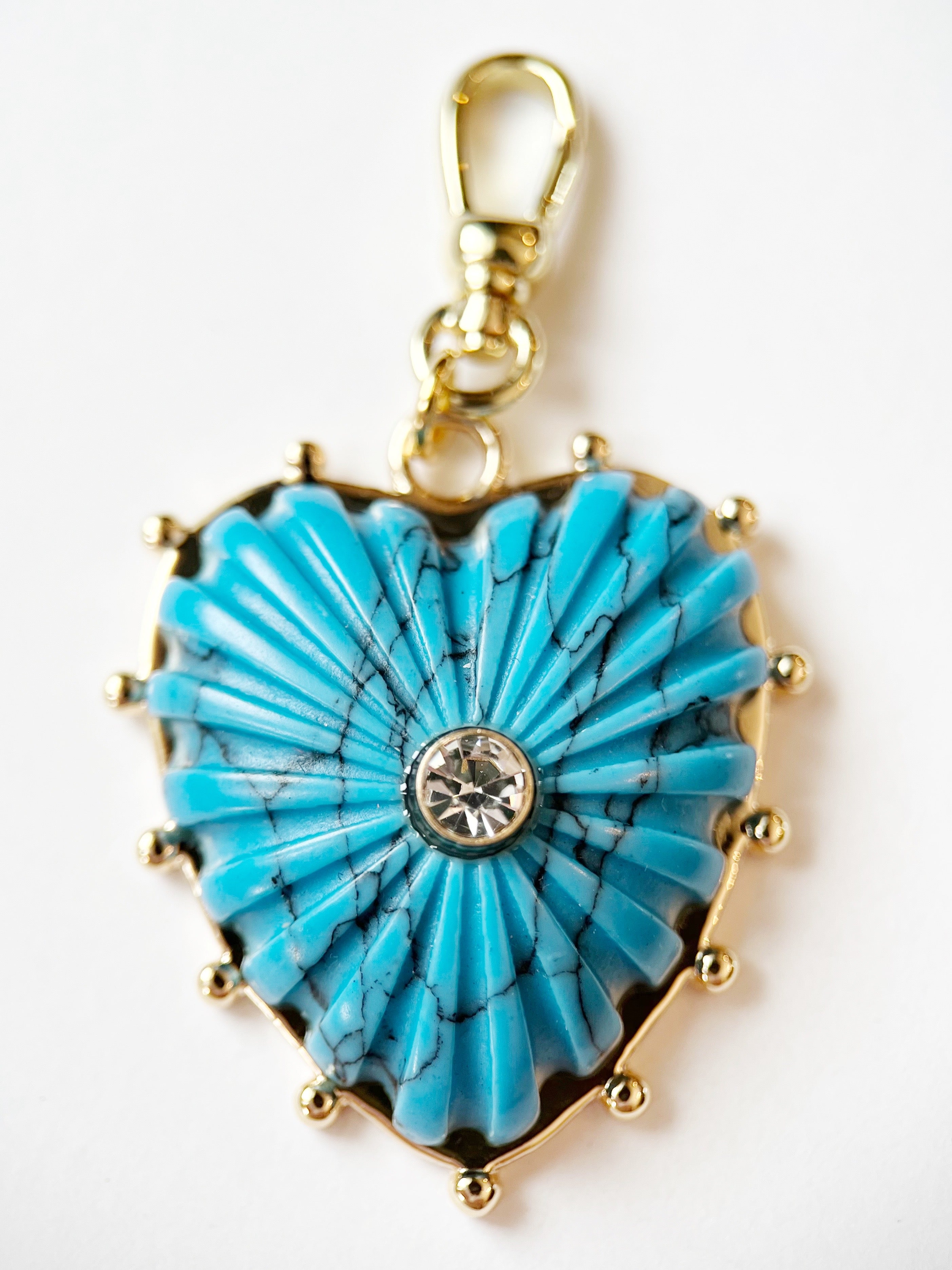 Turquoise heart-shaped pendant with gold accents on a white background