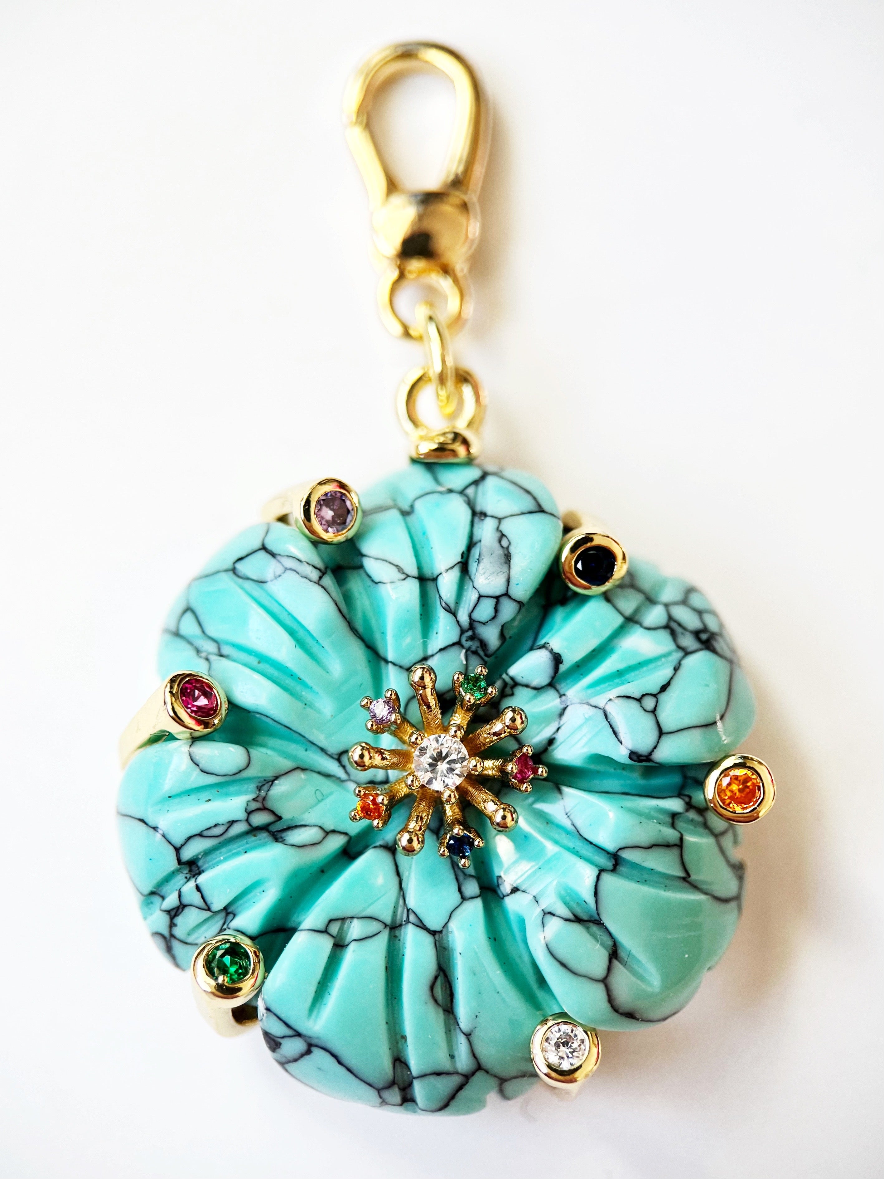 Turquoise floral charm with gemstone accents on a white background