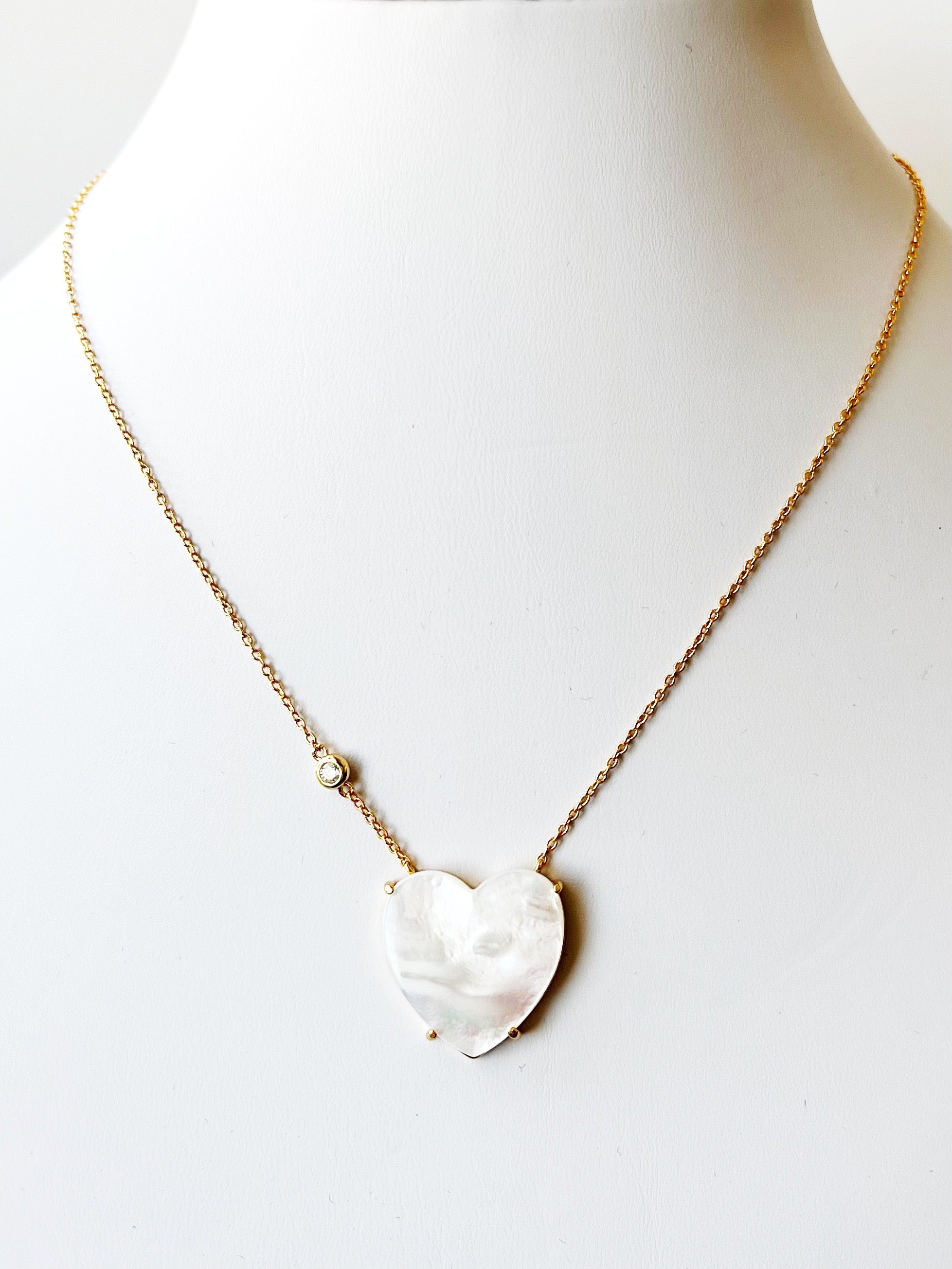 Necklace with a heart-shaped pendant on a mannequin against a white background