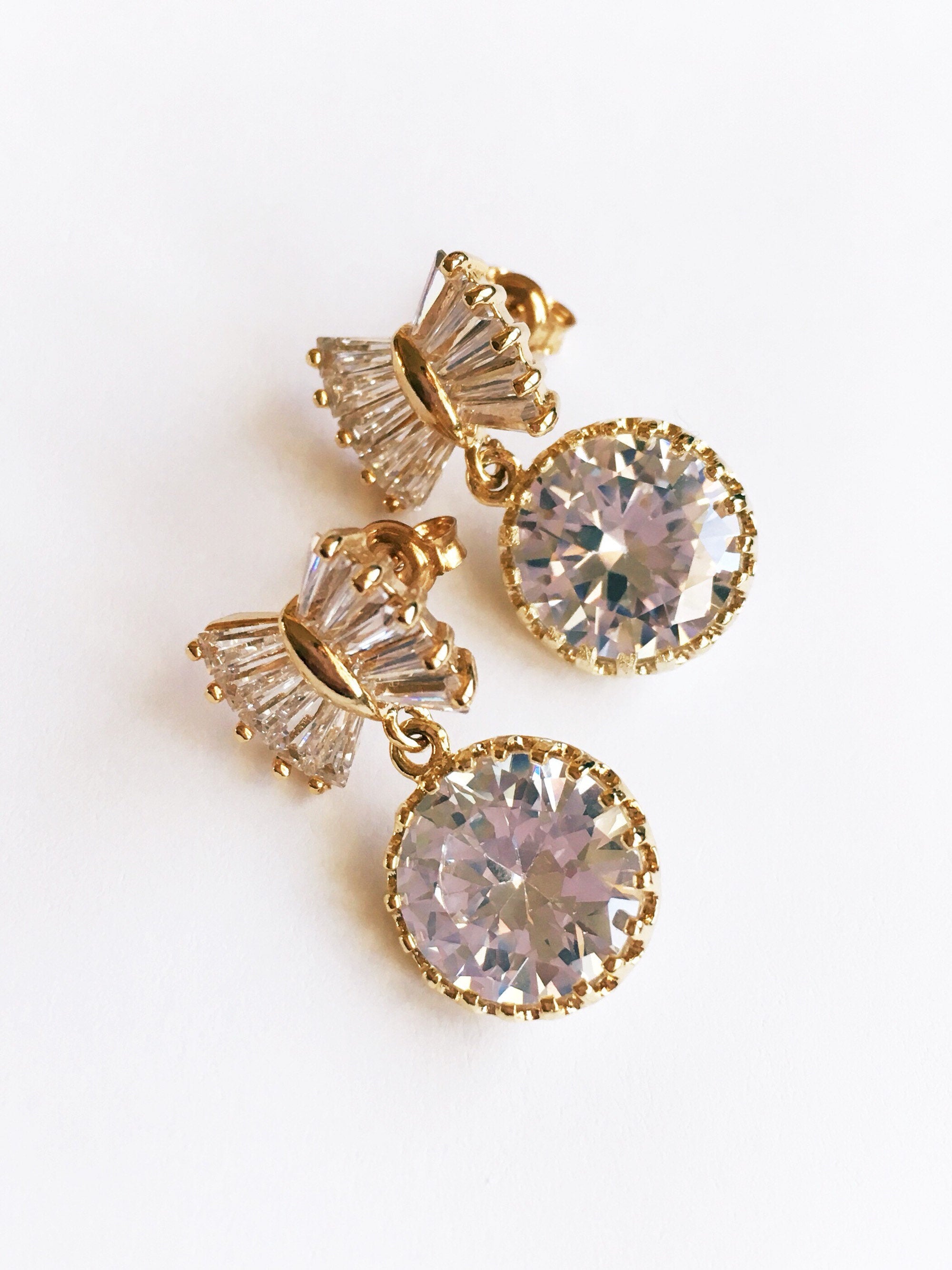 Gold Bow Bridal Drop Earrings with Cubic zirconia teardrop crystals in a yellow gold colored rhodium plated brass setting.