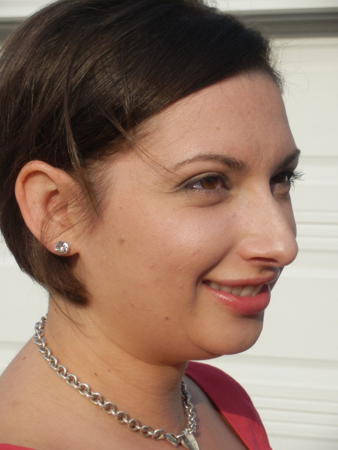 Women wearing Aquamarine Crystal Stud Earrings in silver setting in red top.