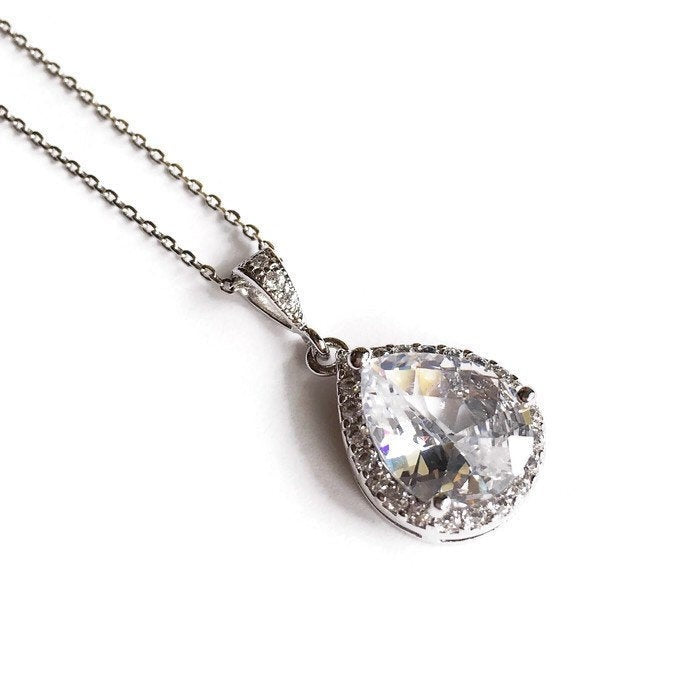 Teardrop cut cubic zirconia crystals set in silver color rhodium plated brass pendant necklace.
