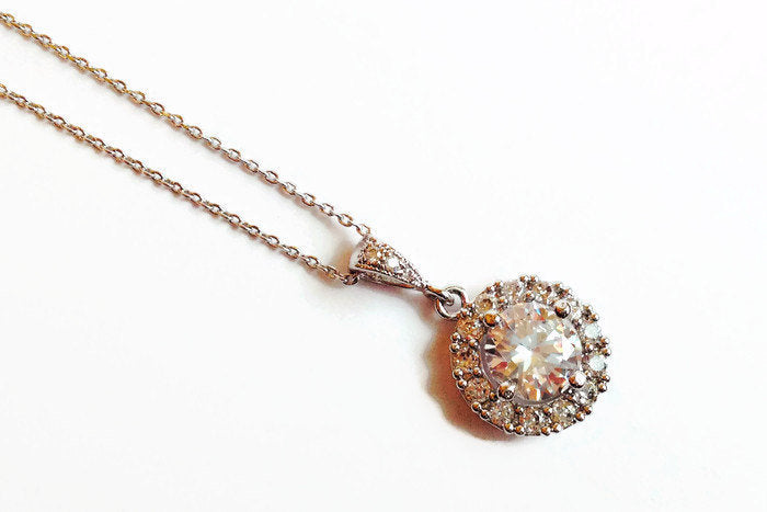 Round cubic zirconia crystal necklace set in silver color rhodium plated brass pendant.
