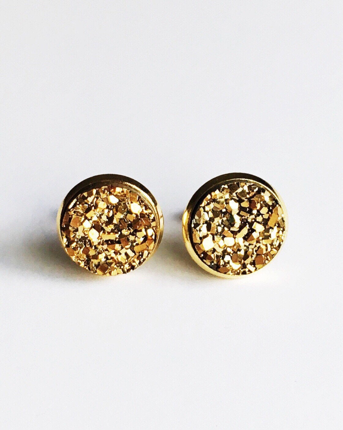 Gold resin druzy stone stud earrings is set in a yellow gold color setting.