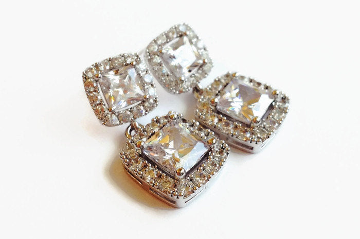 Princess cut Cubic zirconia crystal dangle earrings in a silver colored rhodium plated brass setting