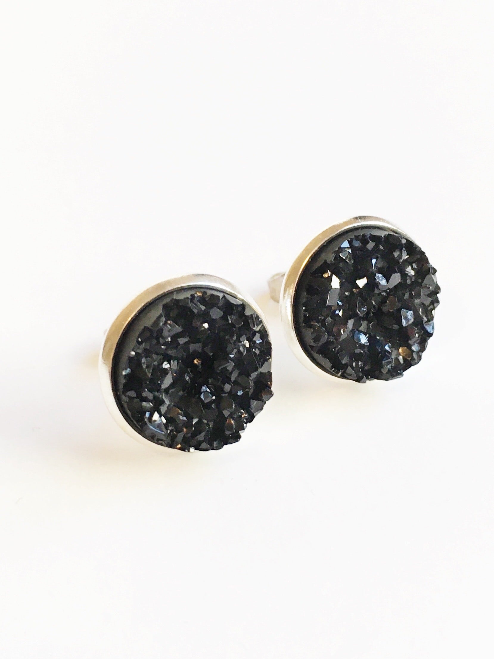 Black resin druzy stone stud earrings set in a silver color setting.