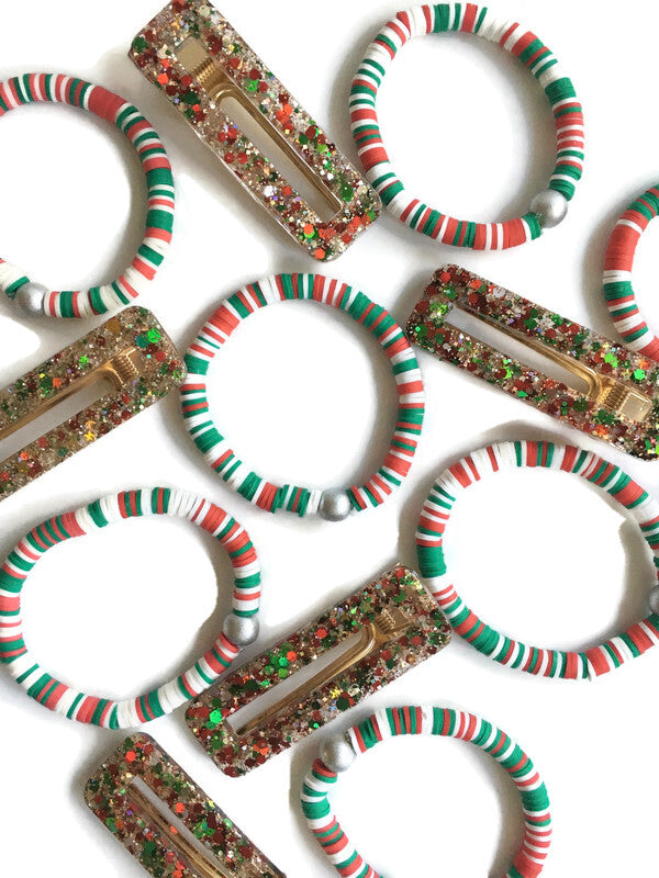 Table full of Red, white, and green confetti bracelet and resin sparkle hair clips laying together.