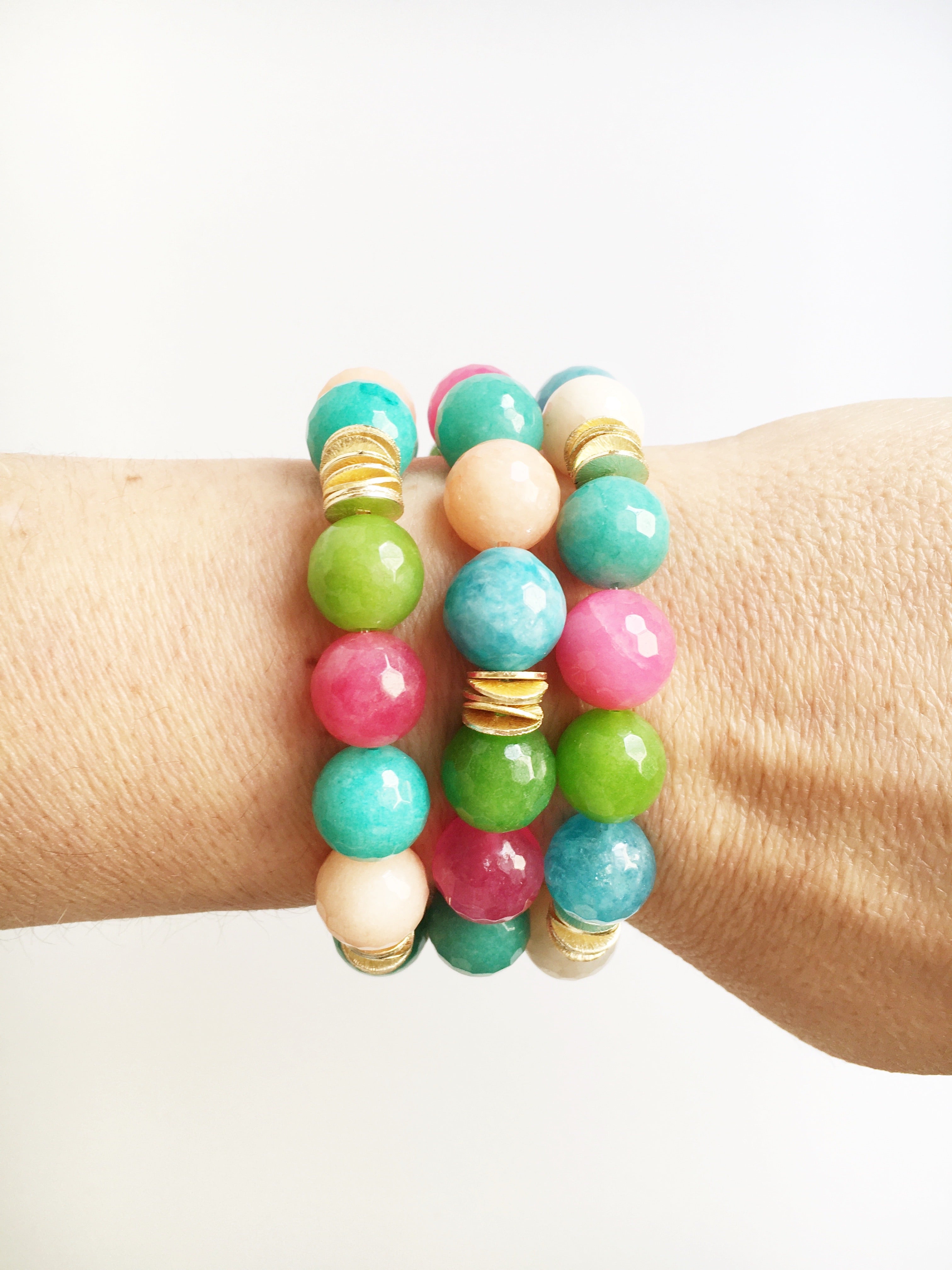Women's wrist wearing three Hand strung agate and gold plated beads on stretch material.