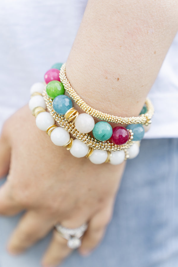 combination of gold, confetti, and agate beaded bracelets laying next to each other