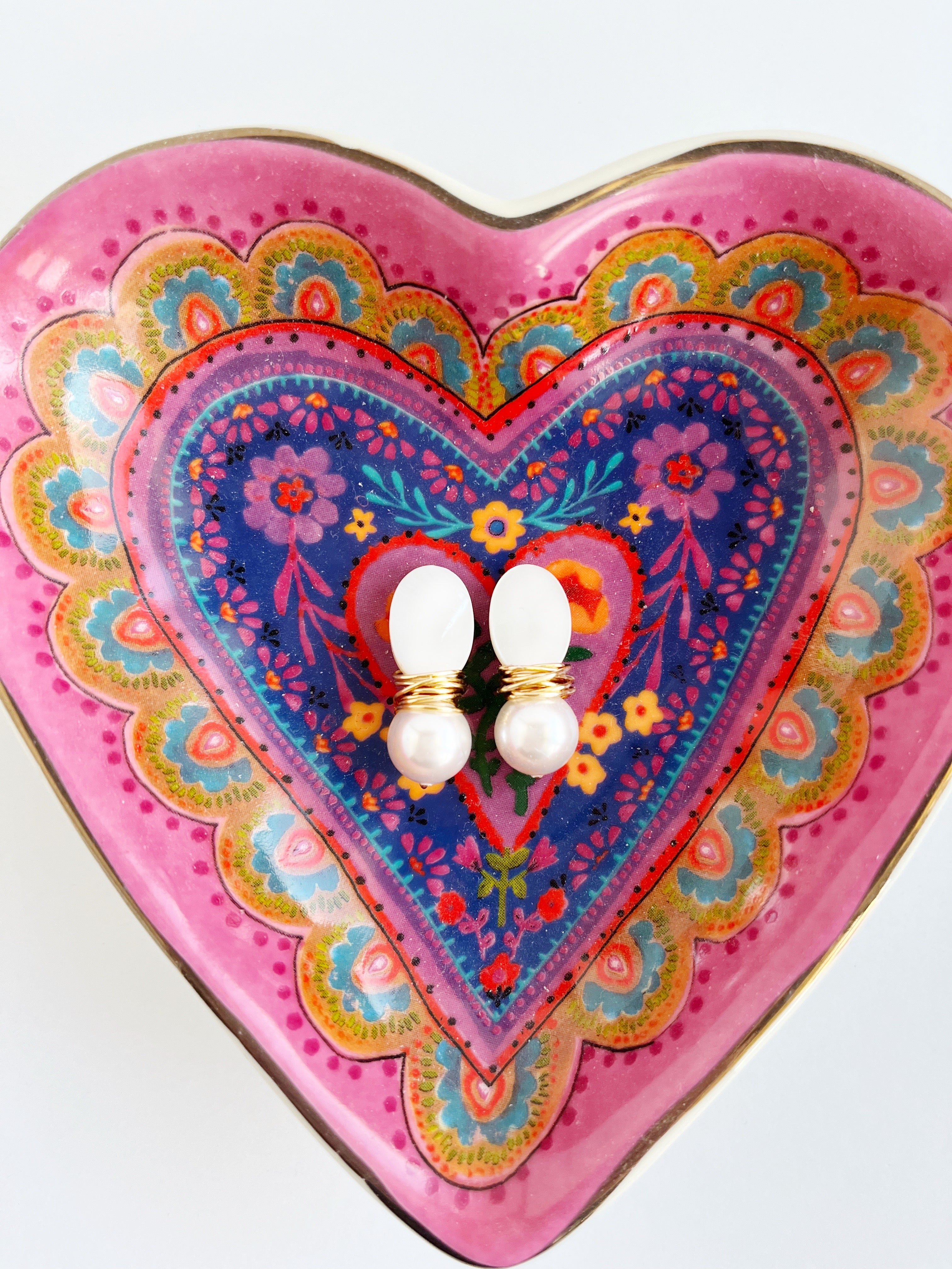 stud pearl drop earrings with gold in heart shaped dish