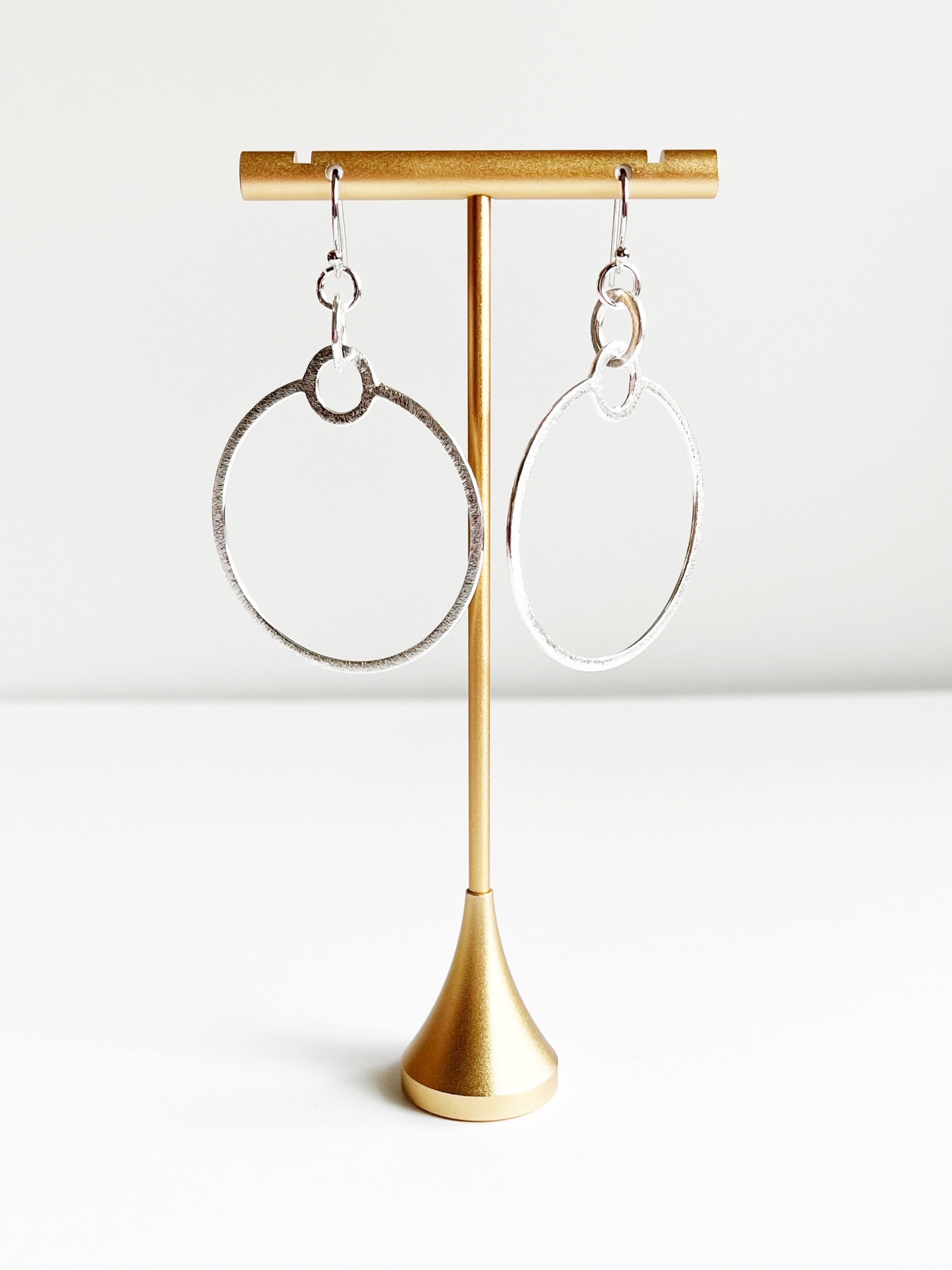 silver statement earrings on gold tstand
