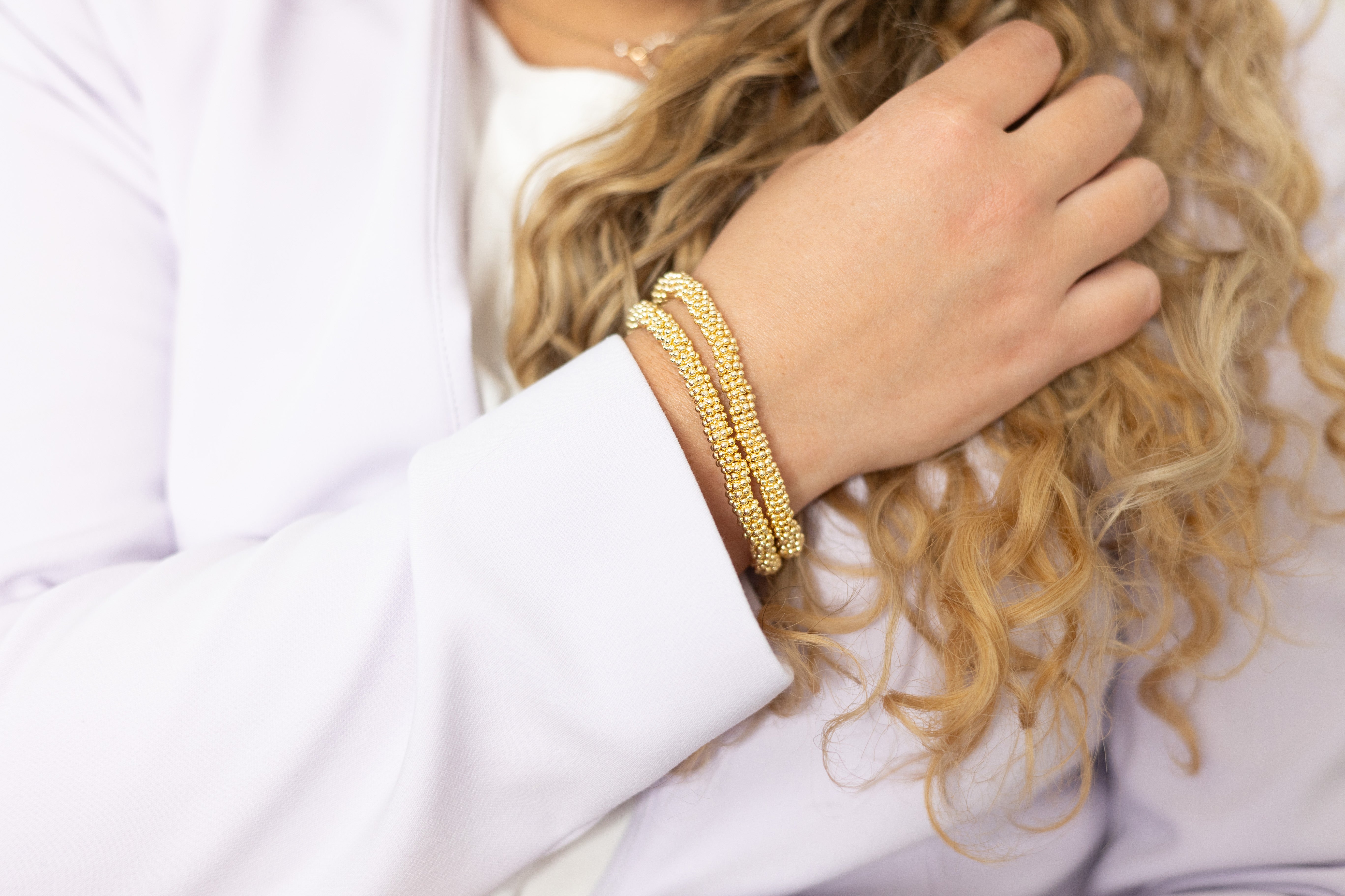gold stacked bracelets displayed on hand