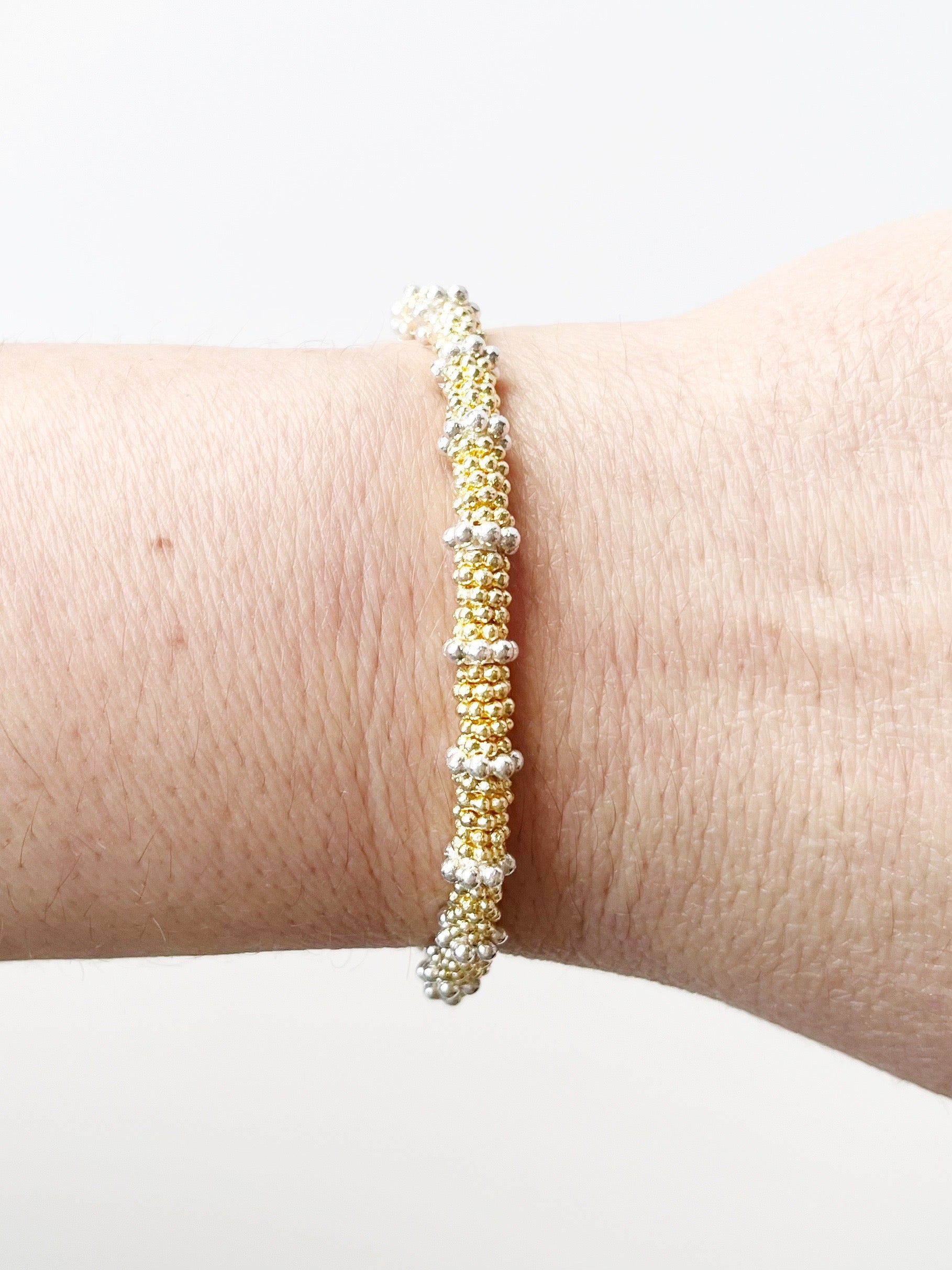 Gold stacking bracelet with silver accents
