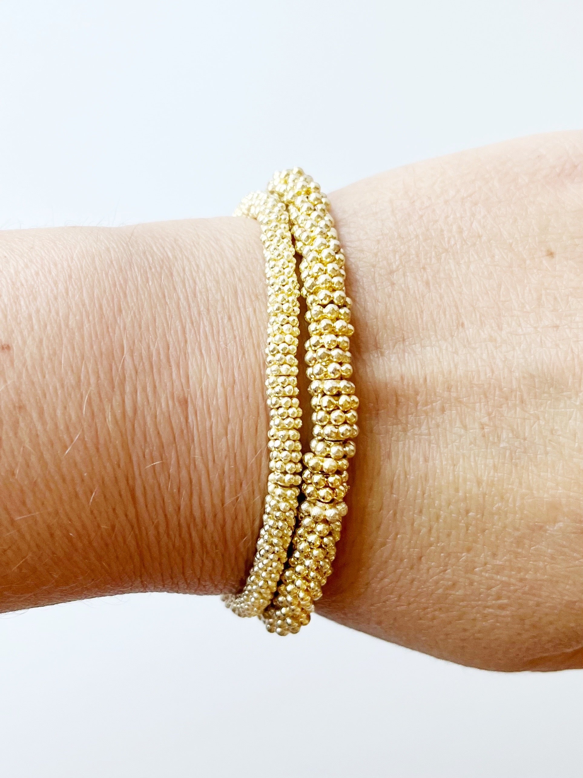 gold stacking bracelets on wrist