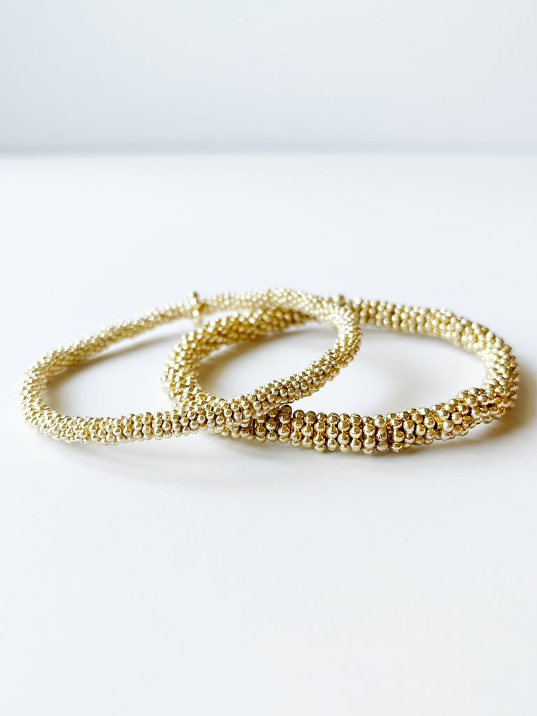 two gold stacked bracelets