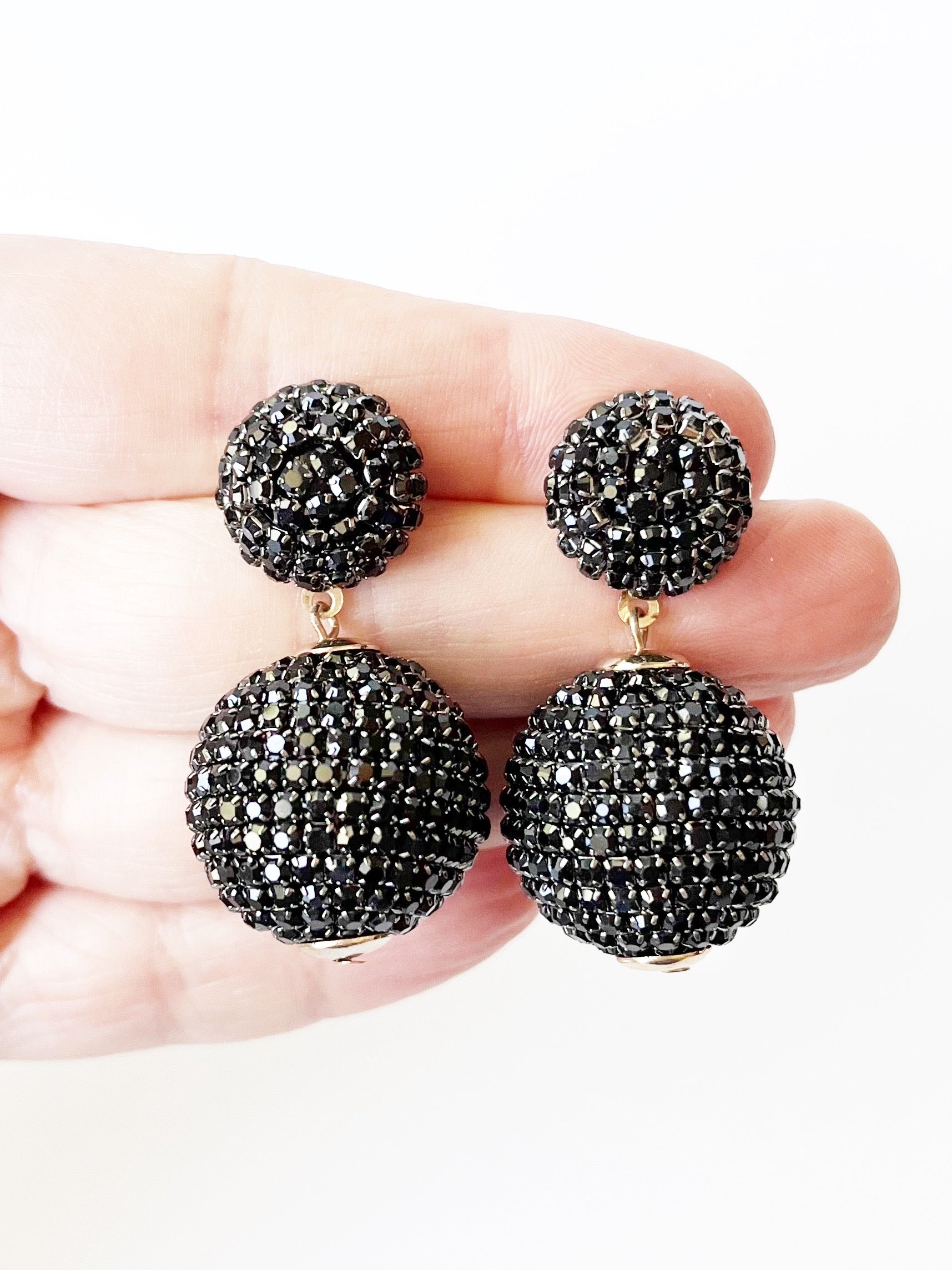 black disco ball earrings on hand