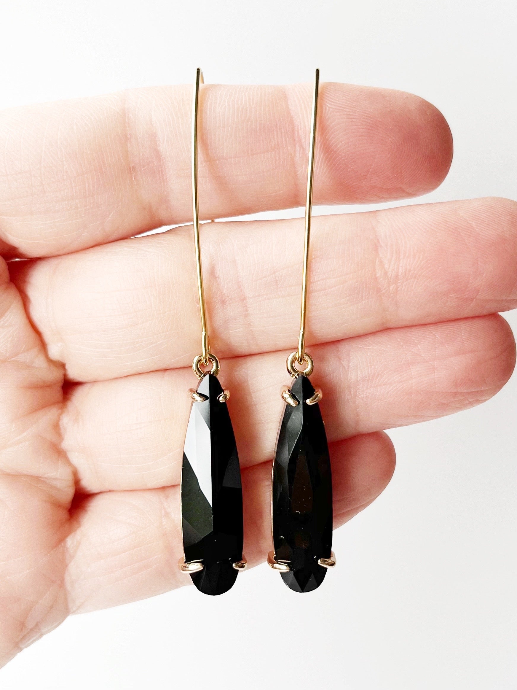 black threader earrings on hand