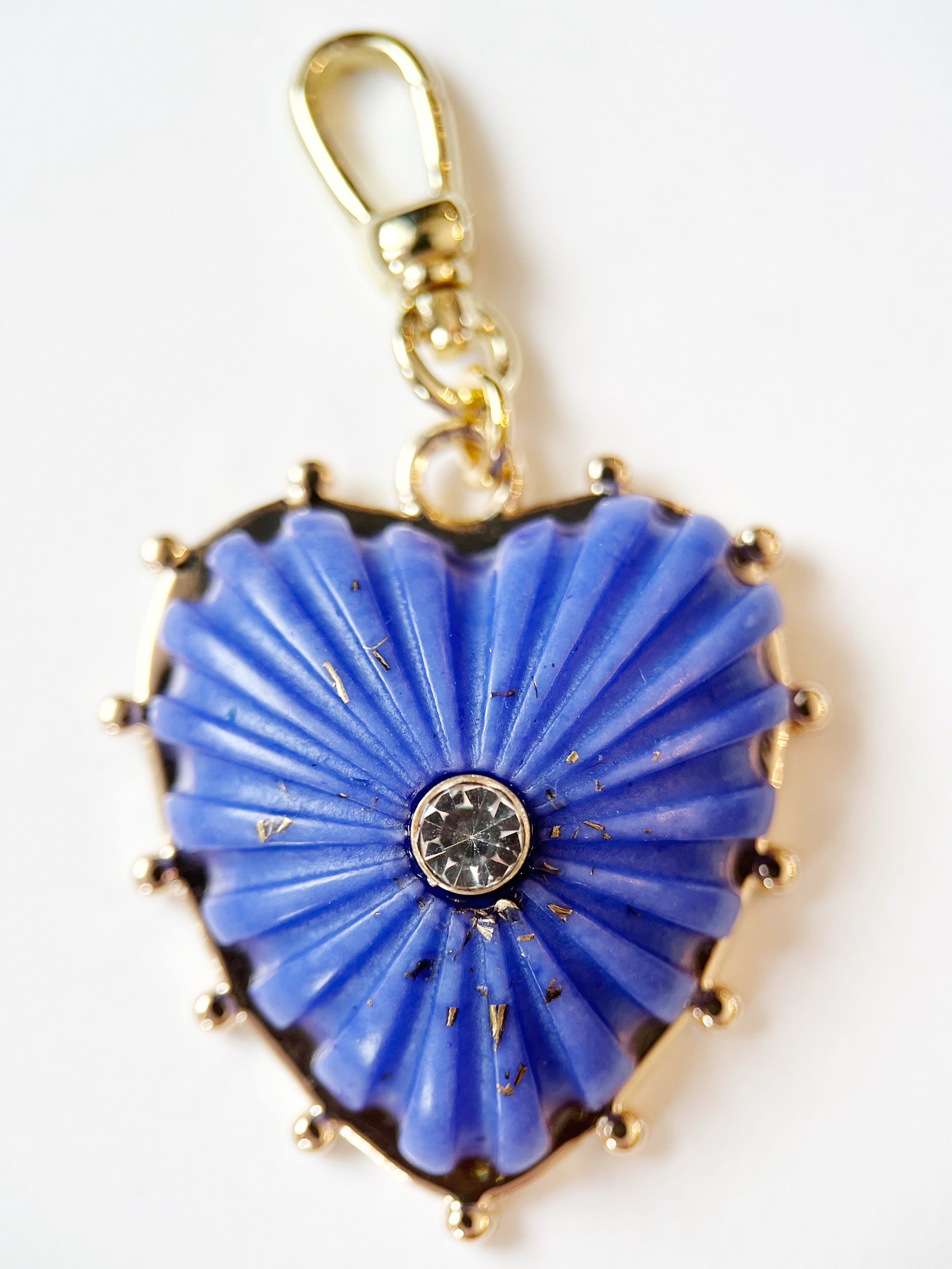 Heart-shaped blue pendant with gold accents on a white background