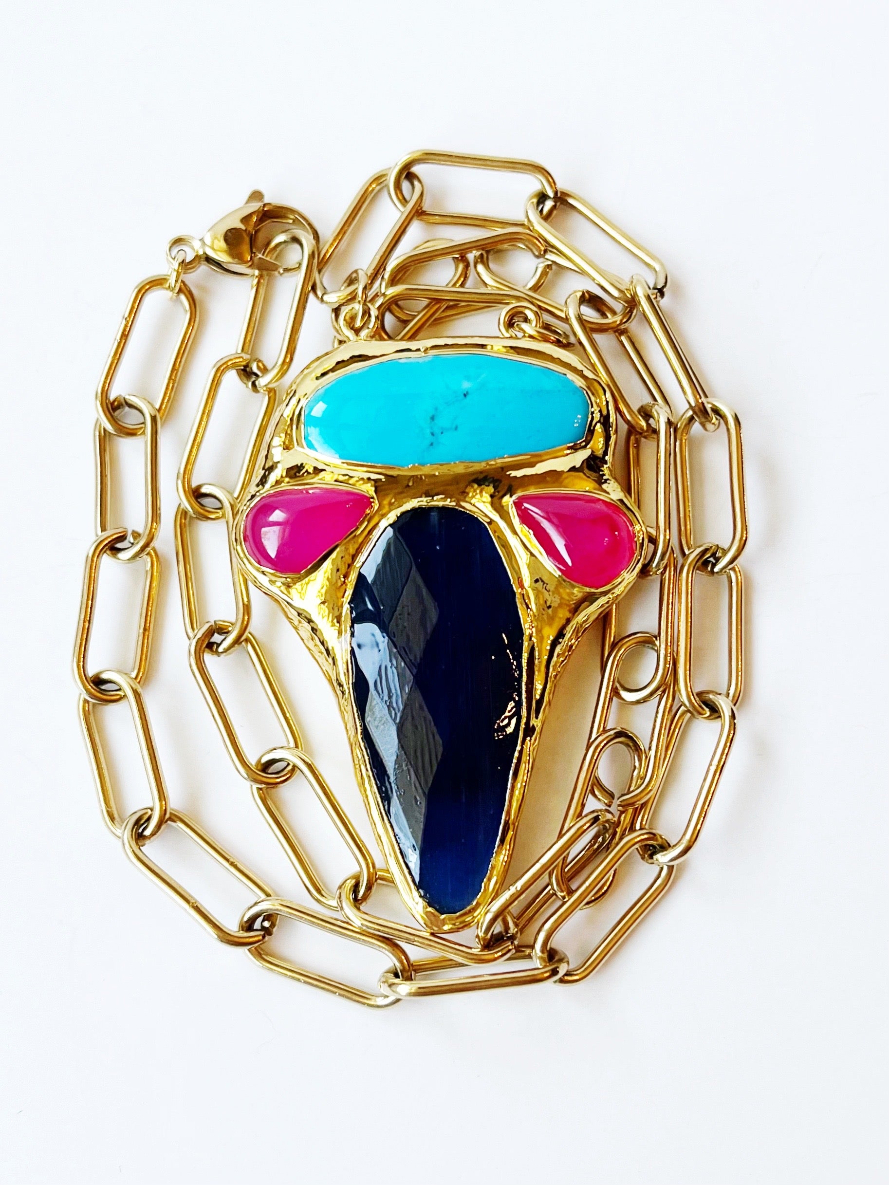 Gold chain necklace with colorful gemstones on a white background