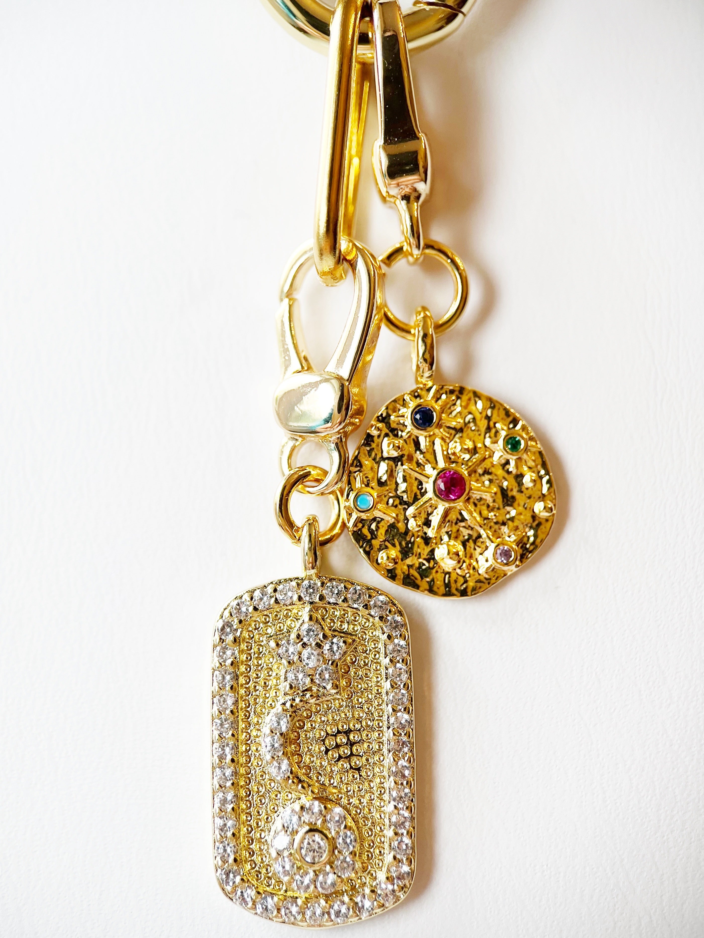 Gold necklace with decorative charms on a white background