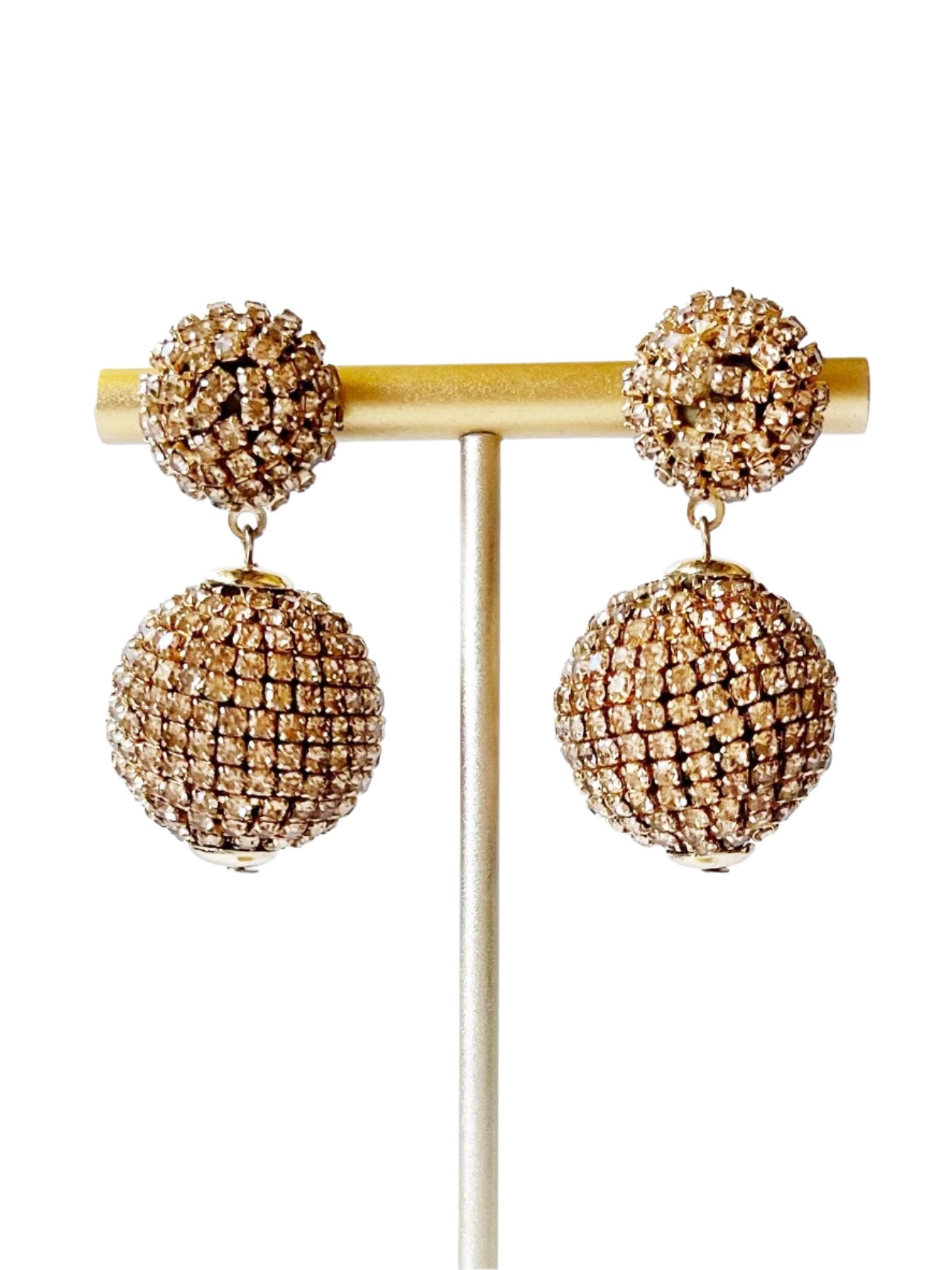 gold crystal dangle earrings on stand