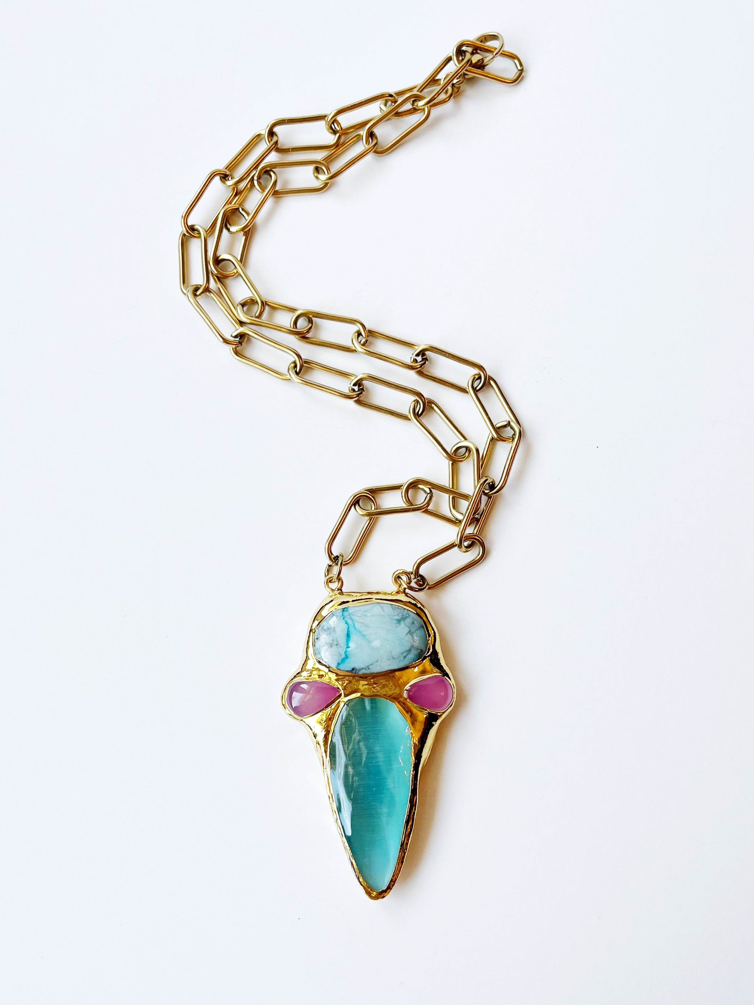 Necklace with a gold chain and turquoise pendant on a white background