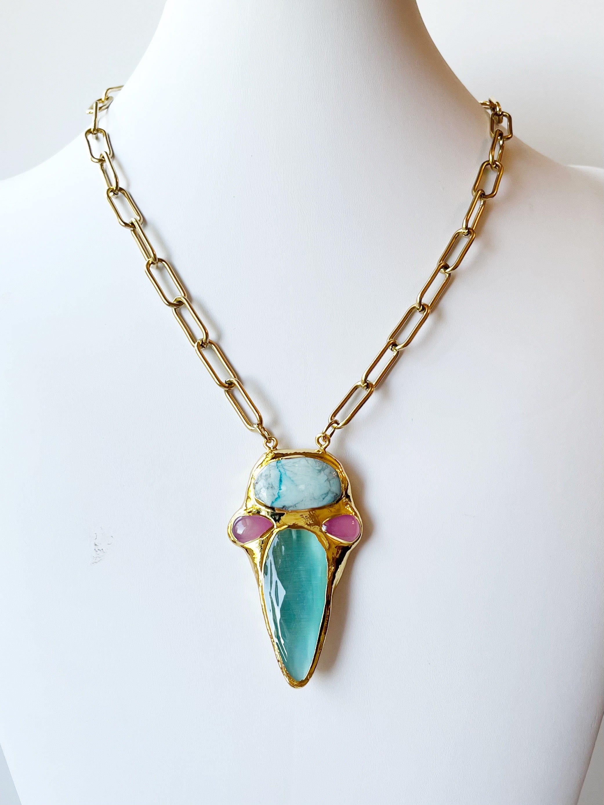 Necklace with a large turquoise pendant on a mannequin against a white background