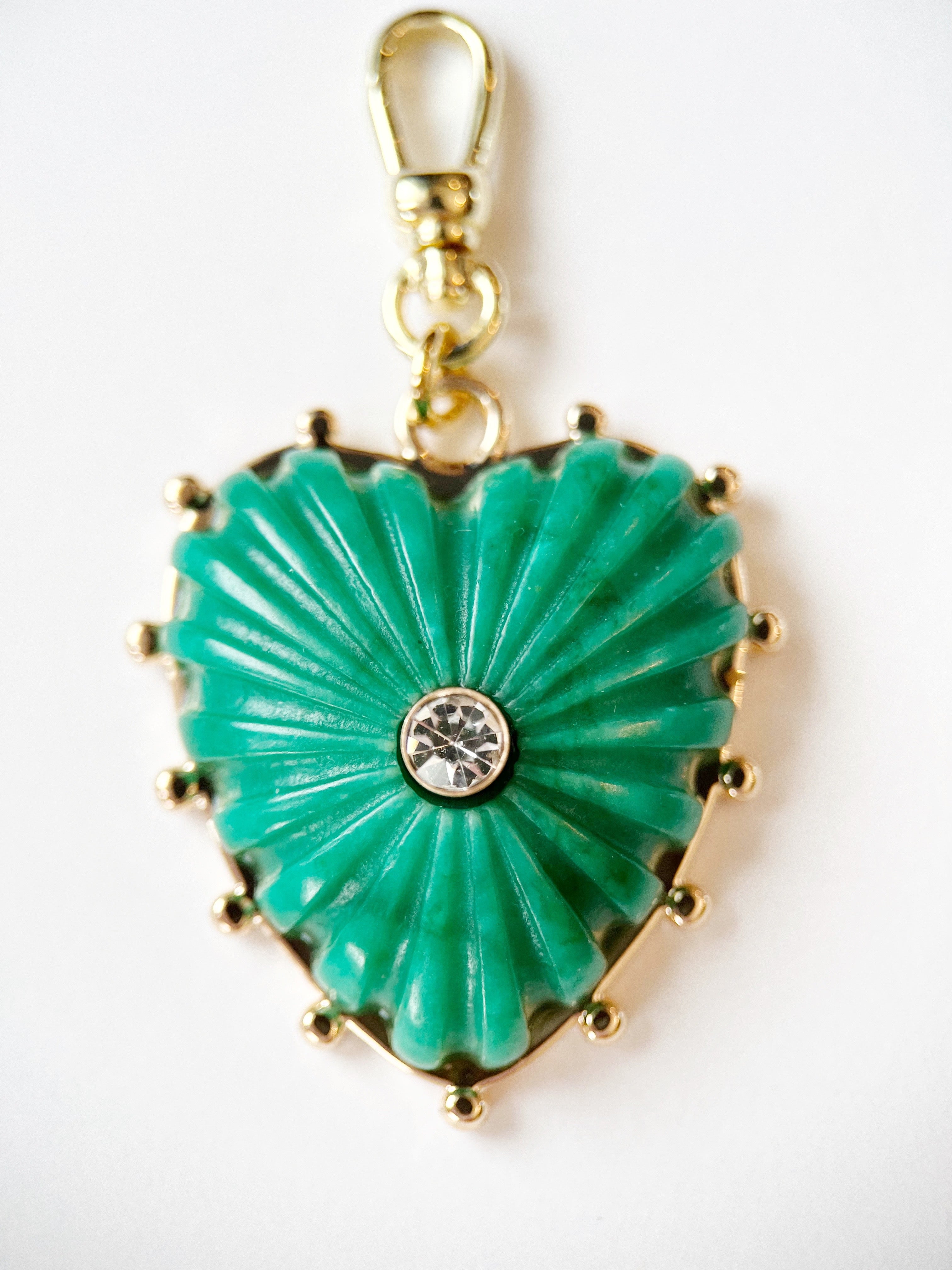 Heart-shaped turquoise pendant with gold accents on a white background