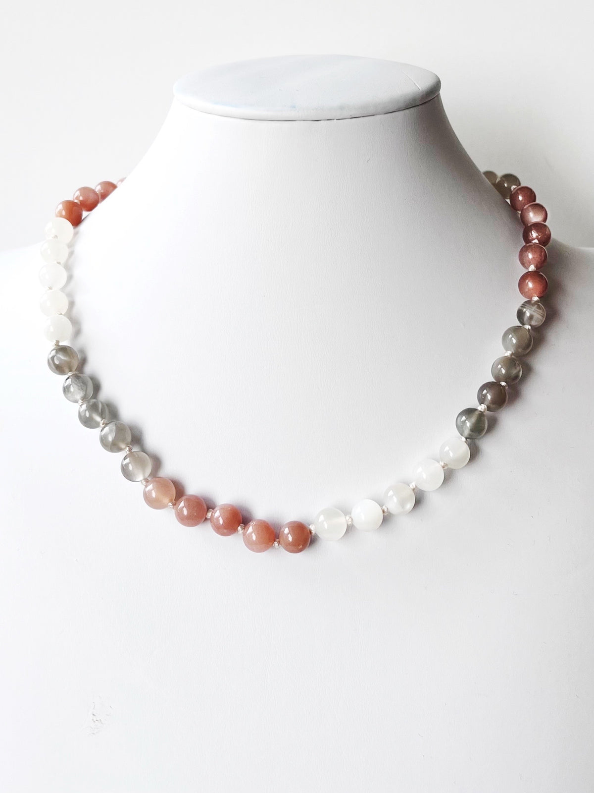 A moonstone beaded necklace displayed on a white mannequin 