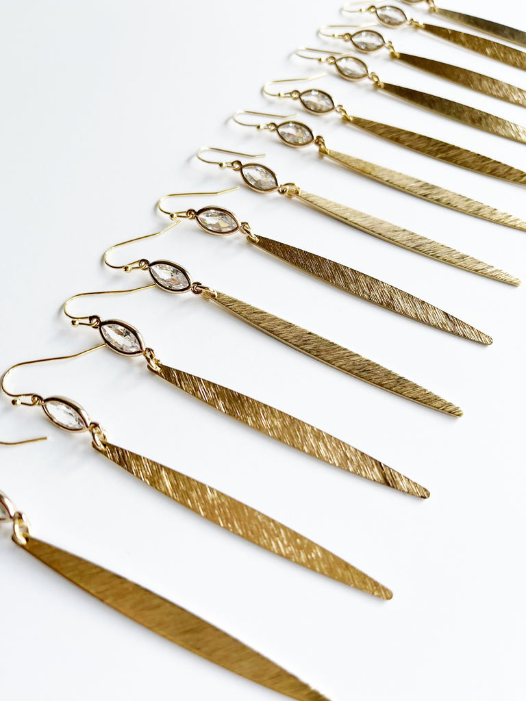 several pairs of long gold earrings