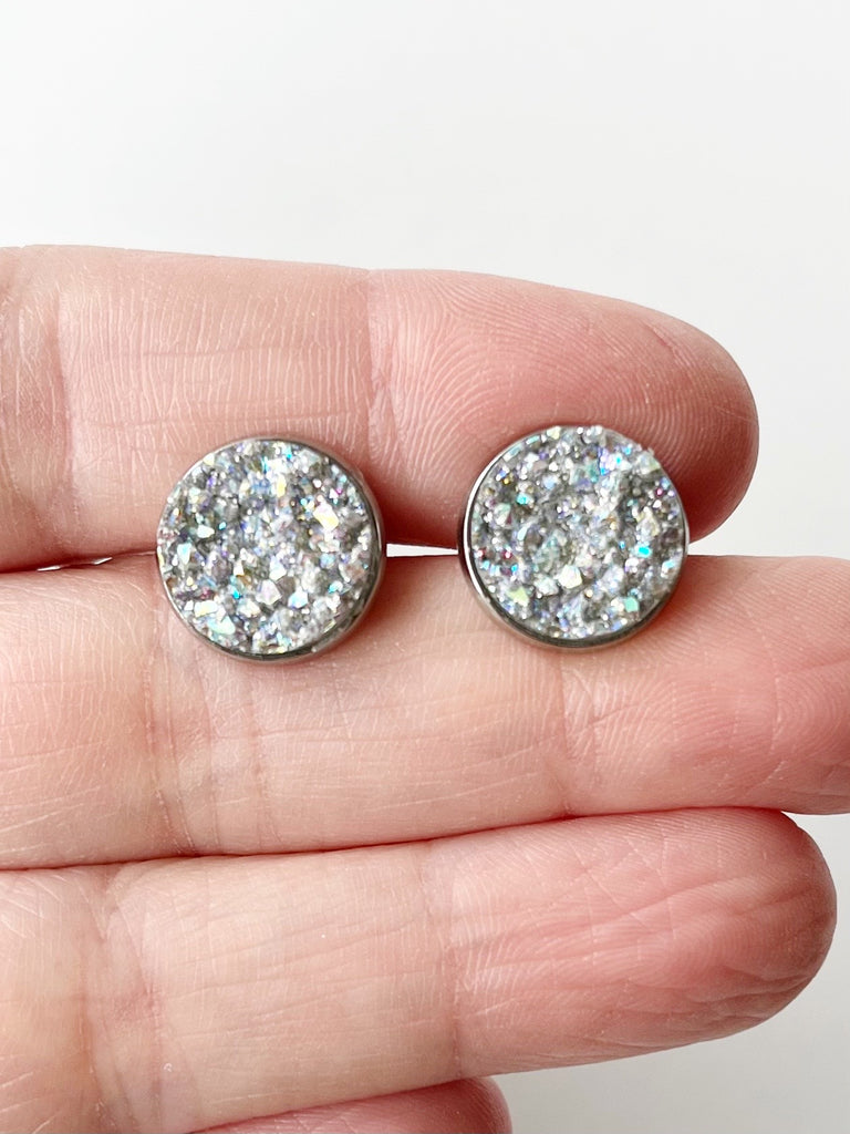 gray silver stud earrings displayed on hand