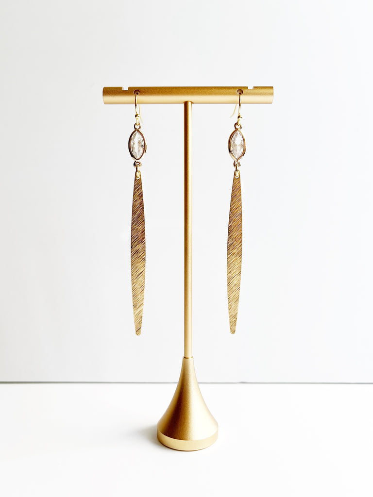 gold minimalist earrings displayed on stand
