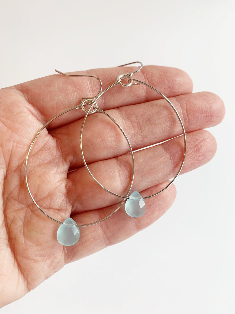 hoop earrings with accent bead displayed on hand