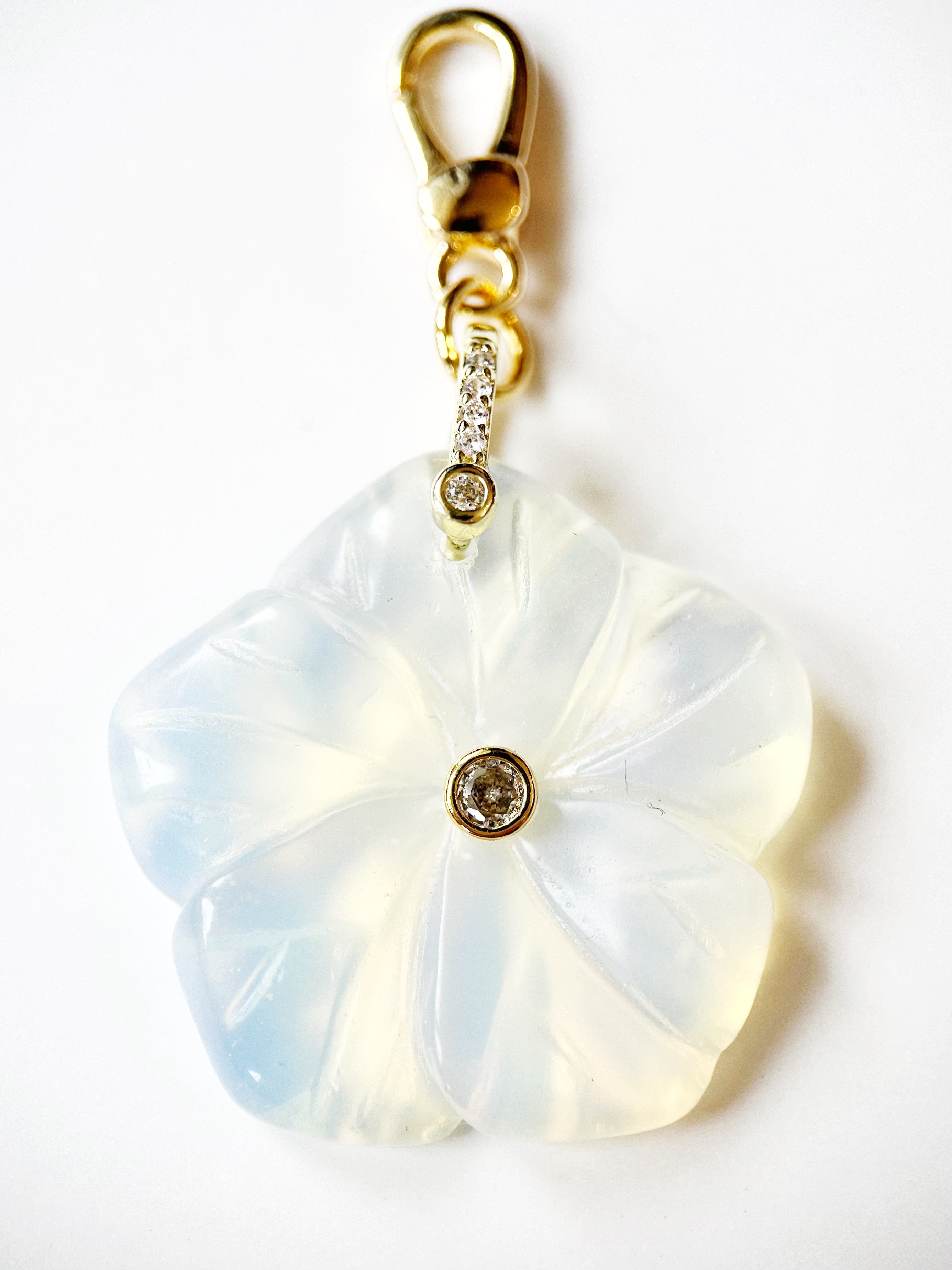 Floral-shaped keychain with gold accents on a white background