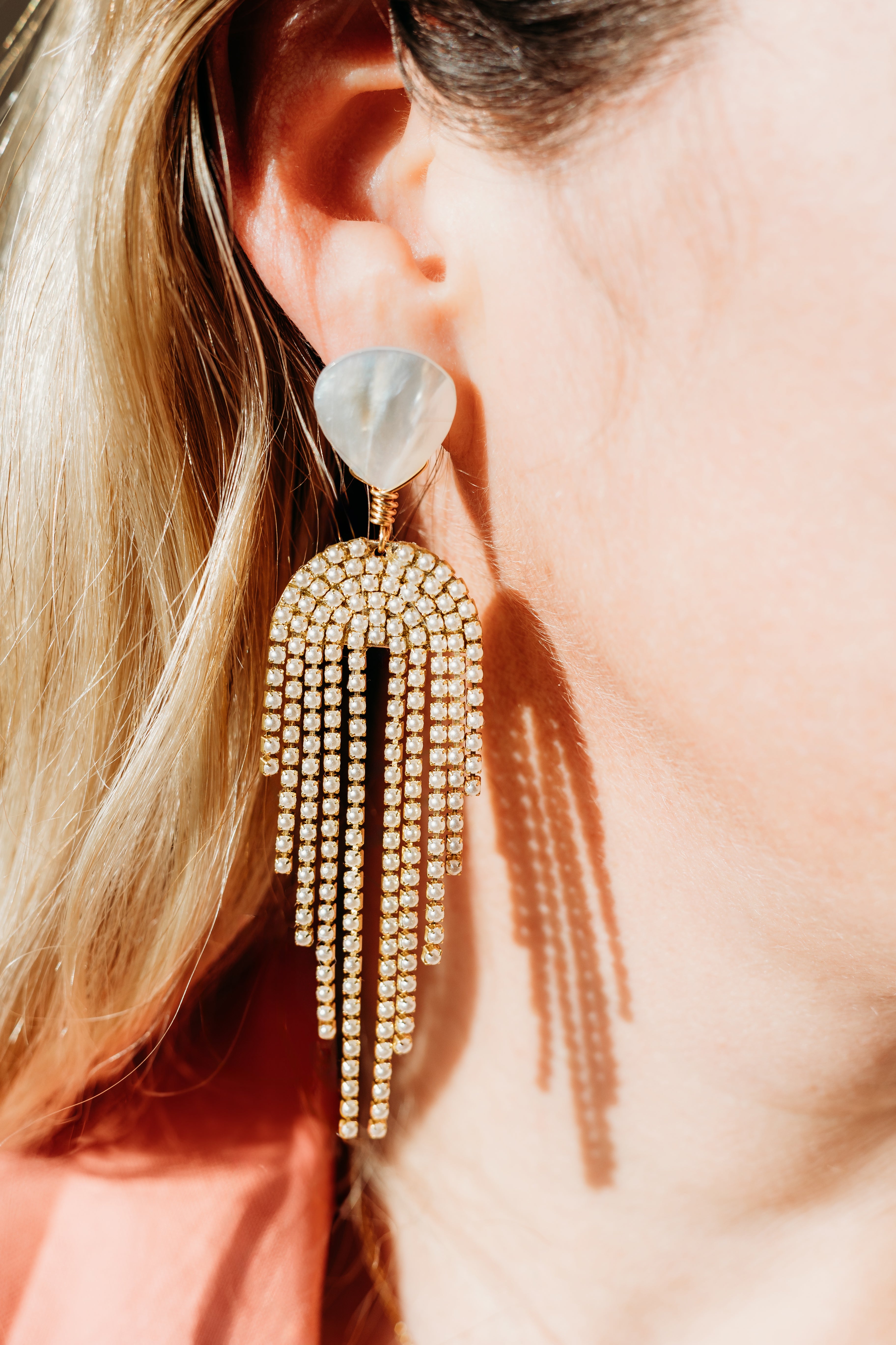 woman wearing pearl statement earrings