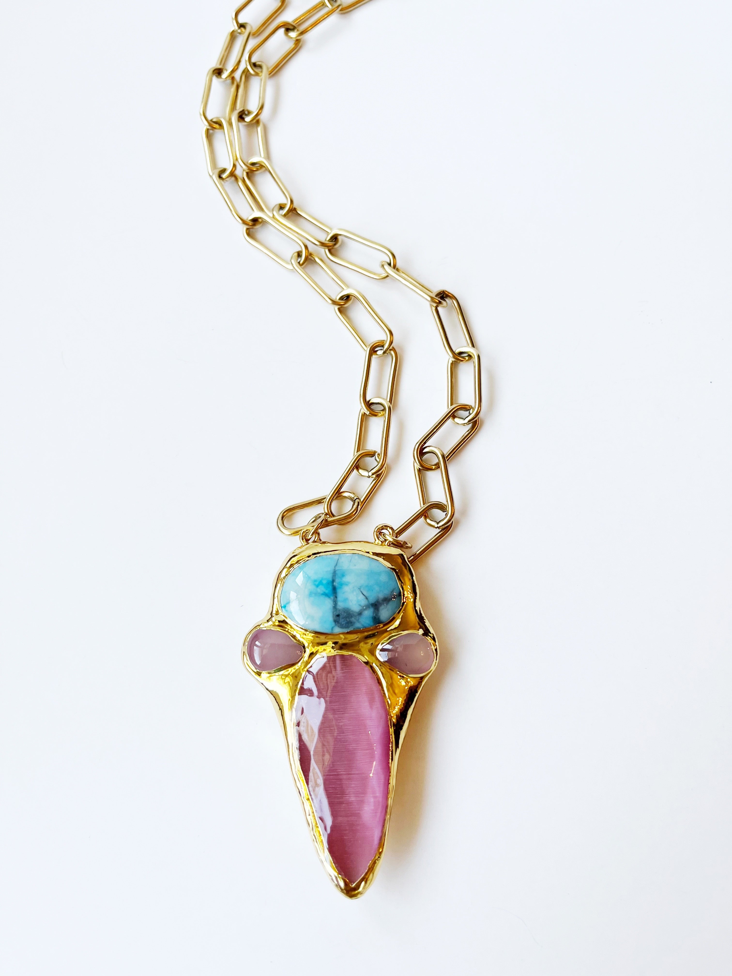 Necklace with gold chain and colorful pendant on a white background