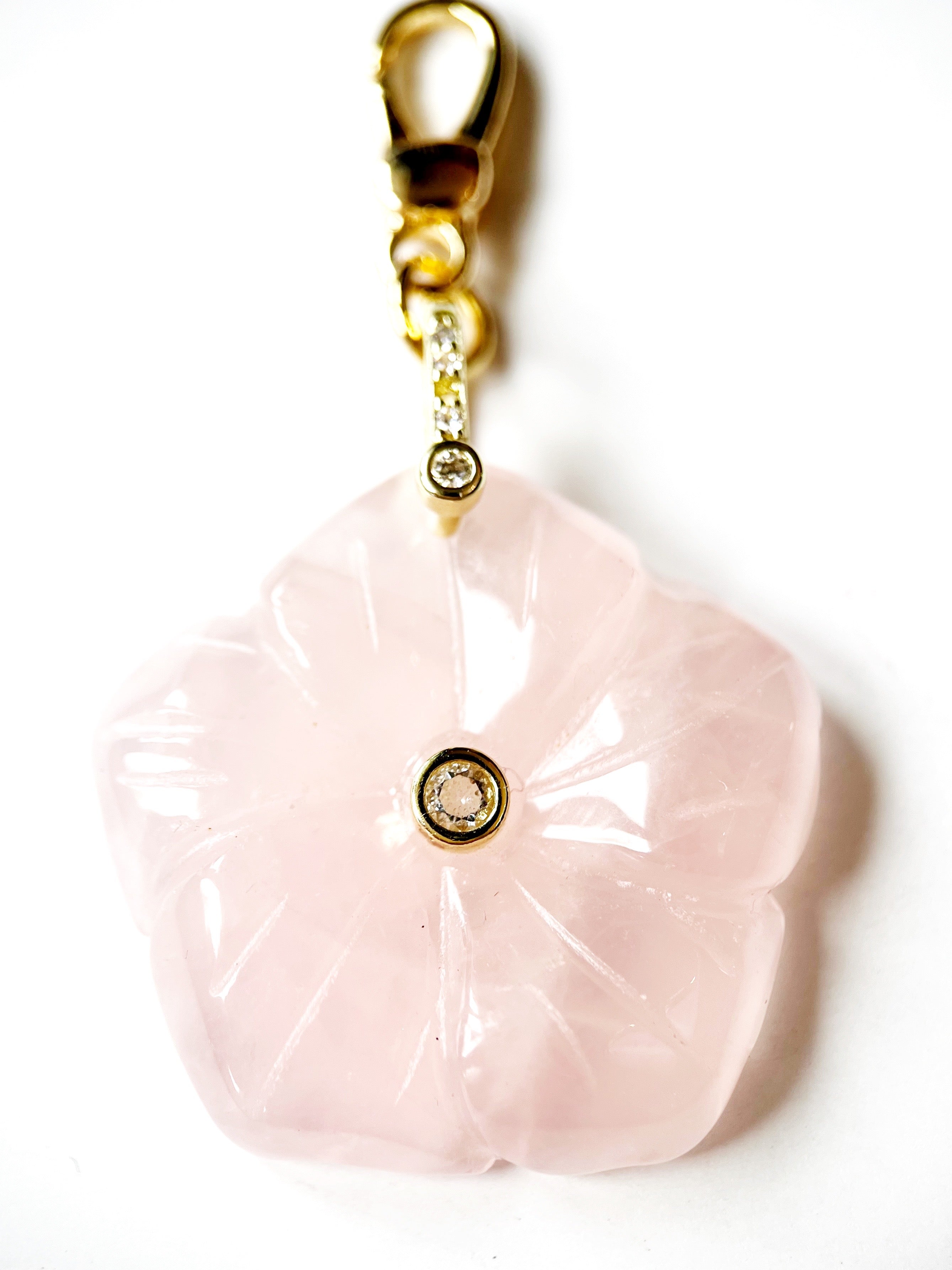 Pink flower charm with gold accents on a white background