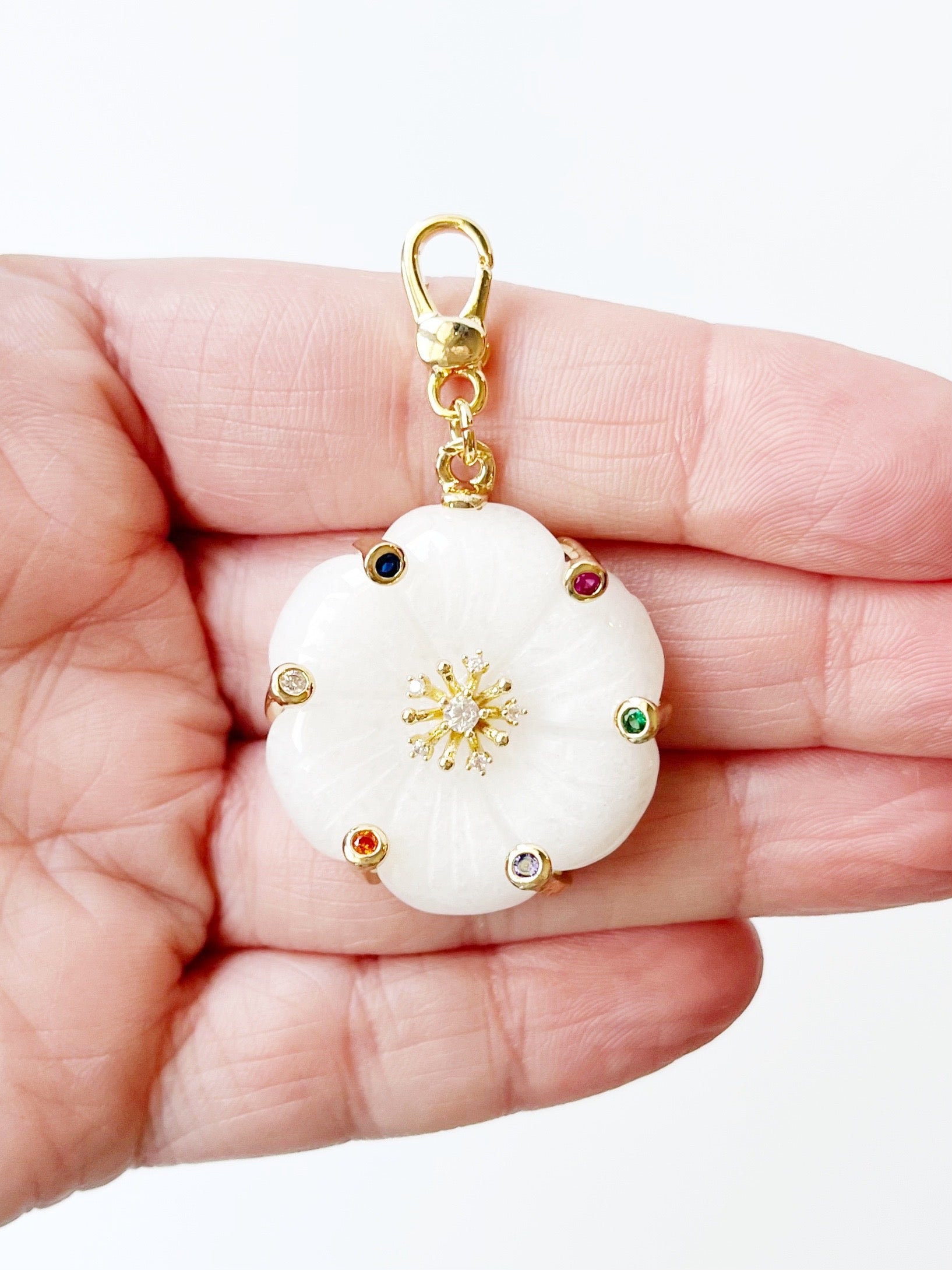 white flower pendant displayed on hand