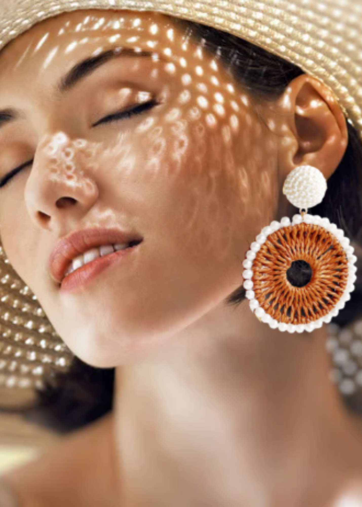 Close-up of a woman wearing large, decorative earrings with a blurred background
